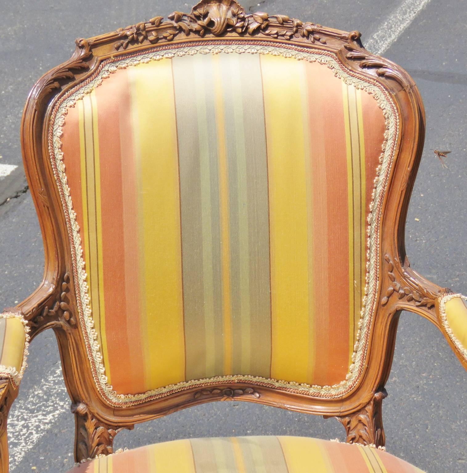 Carved walnut frames. Striped upholstered backs and seats.