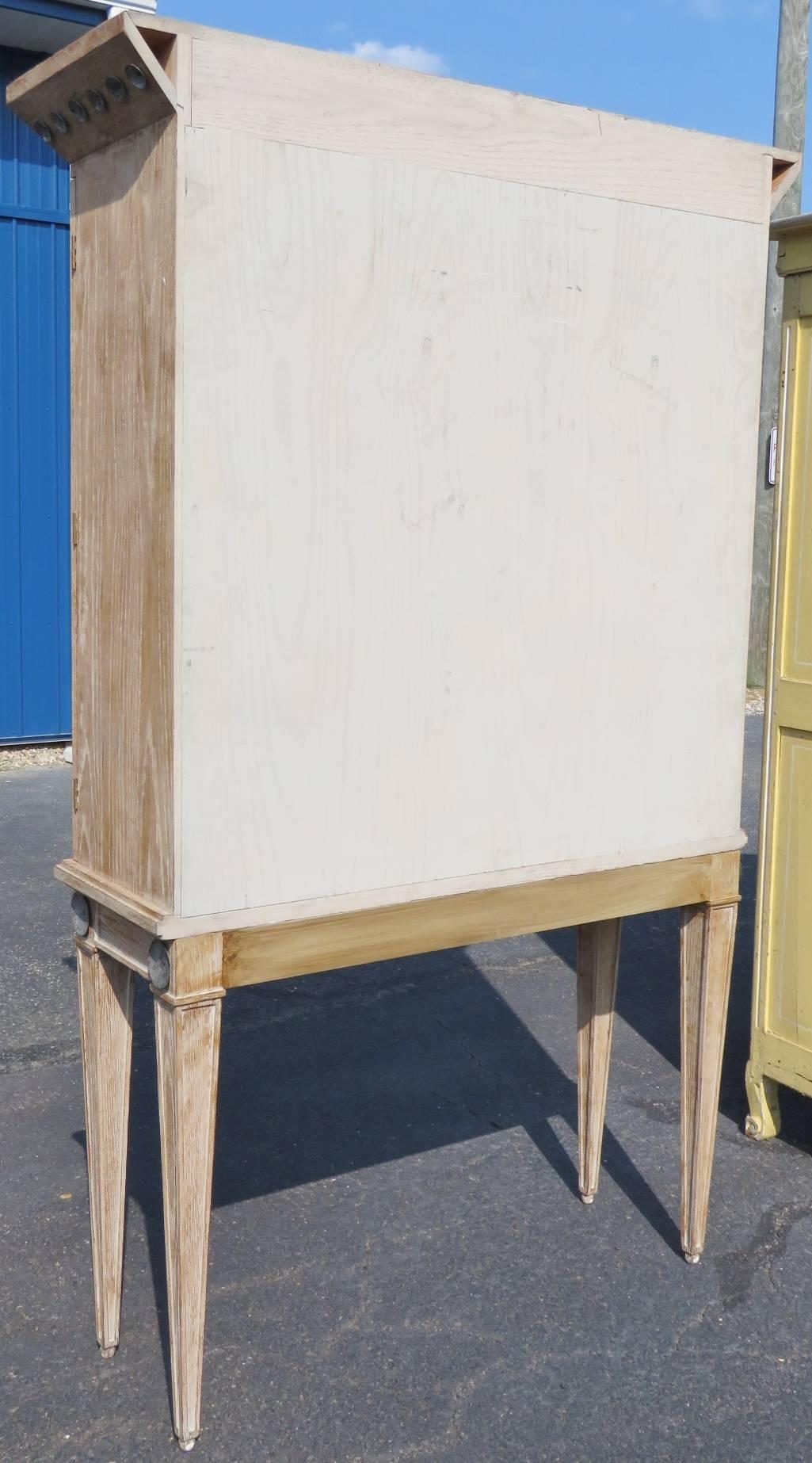 Distressed painted frame. Silver gilt paint decorated glass doors.