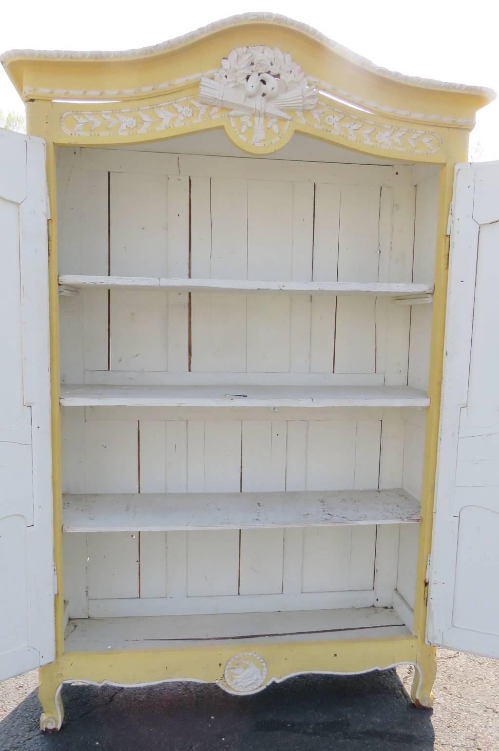Yellow and white distressed painted frame with floral decoration. Inside has white painted shelves for storage.