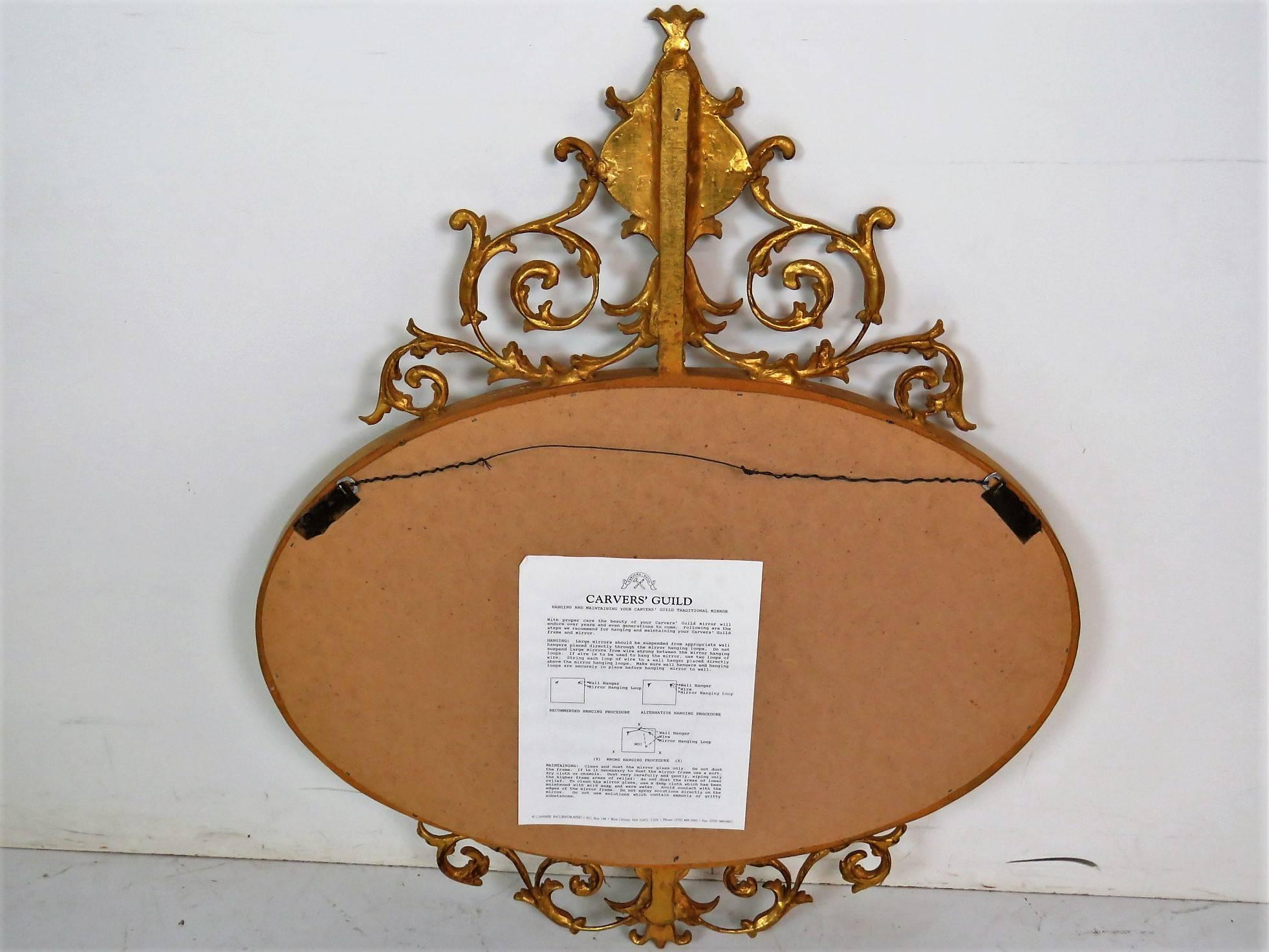 Beveled glass mirror. Gilt carved frame with classical figural pendant.
