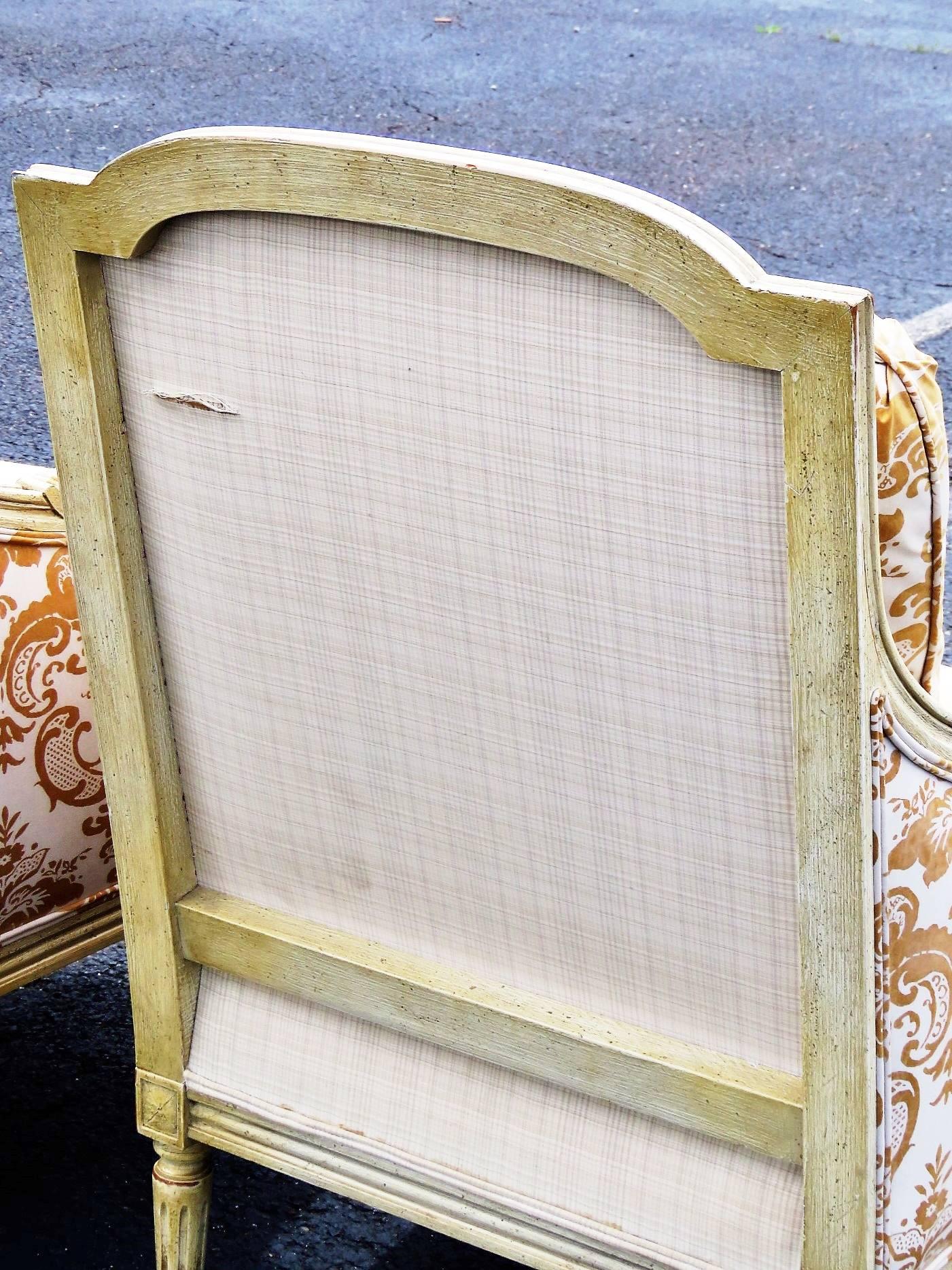 Distressed cream painted carved frames. Yellow and cream damask upholstery.