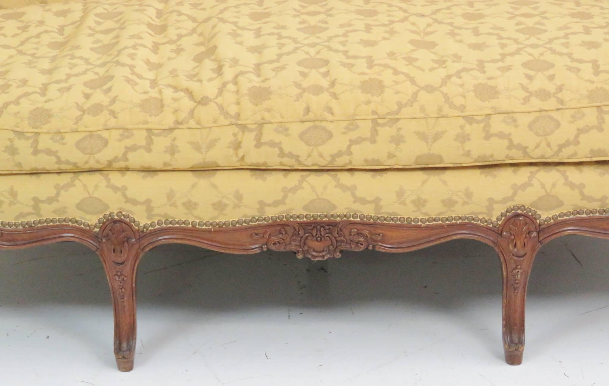 Carved walnut frame. Yellow decorative upholstery.