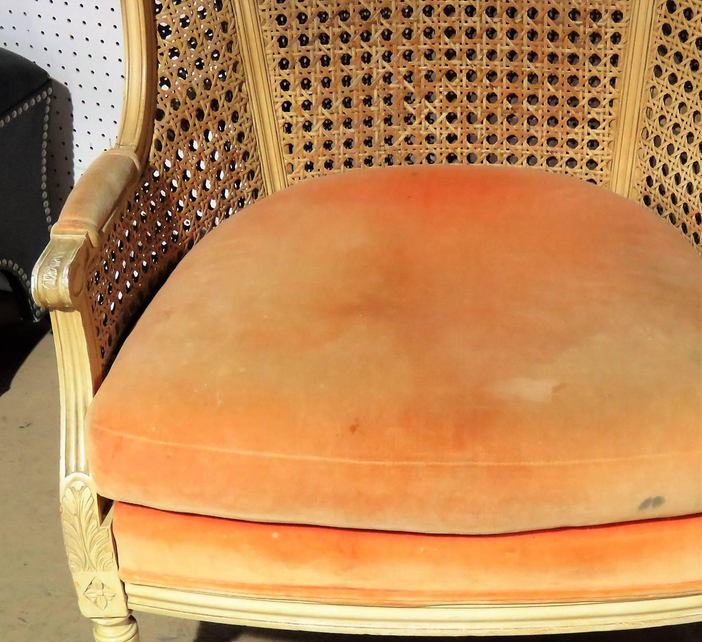 Distressed painted caned backs. Orange upholstered seats.