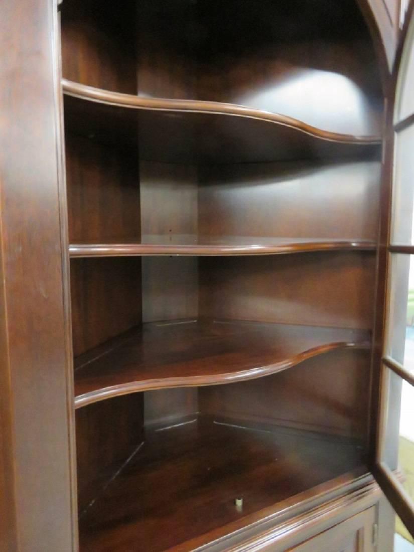 Mahogany with glass doors and three mahogany shelves. Two bottom doors that open for storage.