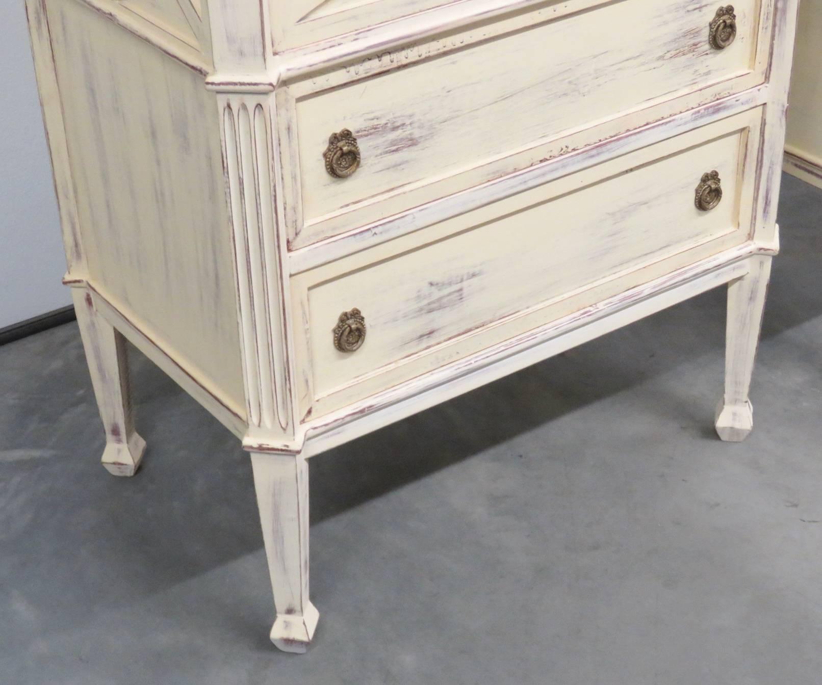 Distressed cream painted with three drawers and brass hardware.