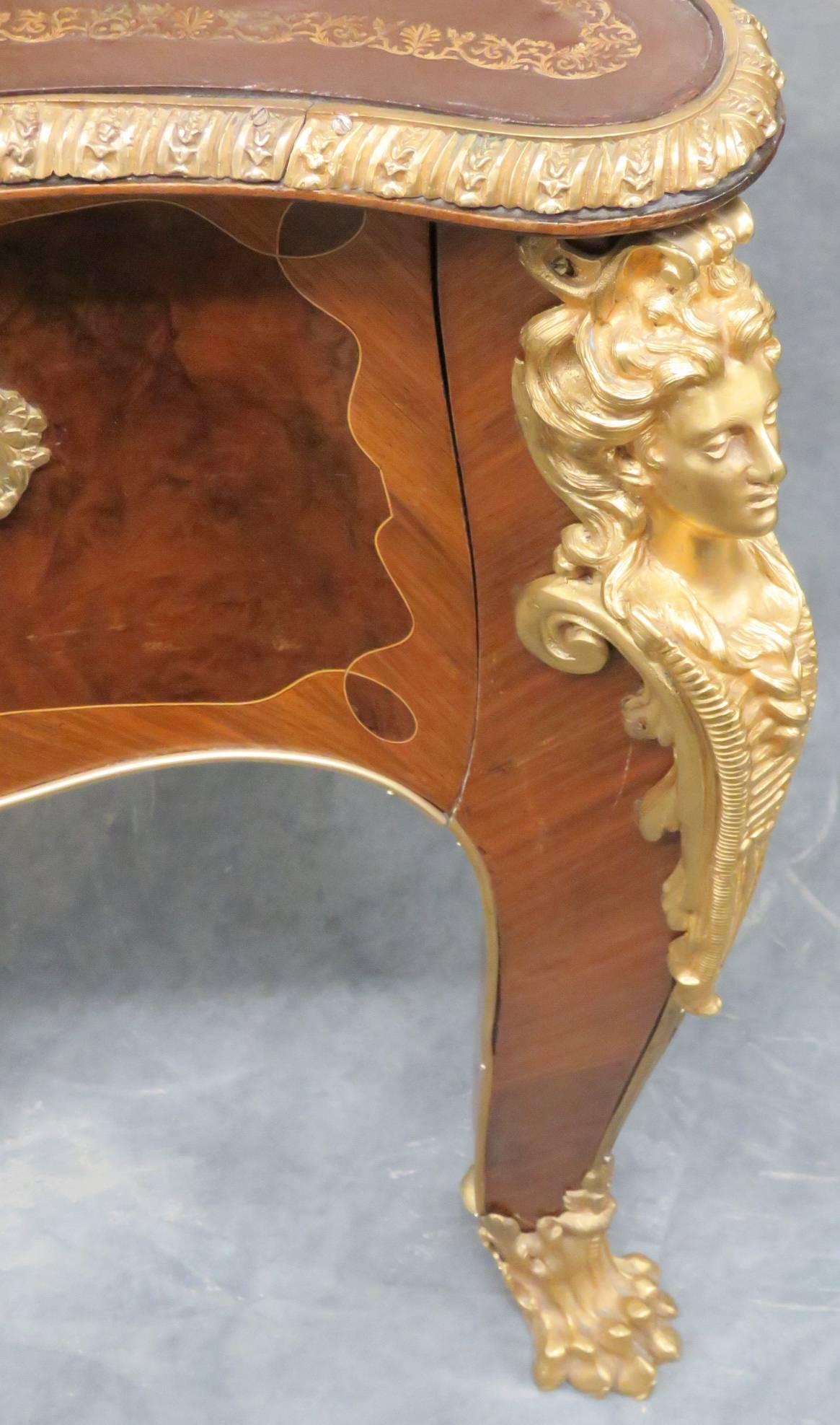Figural mounts, claw feet and hardware. Brown leather top. Parquetry inlaid frame.