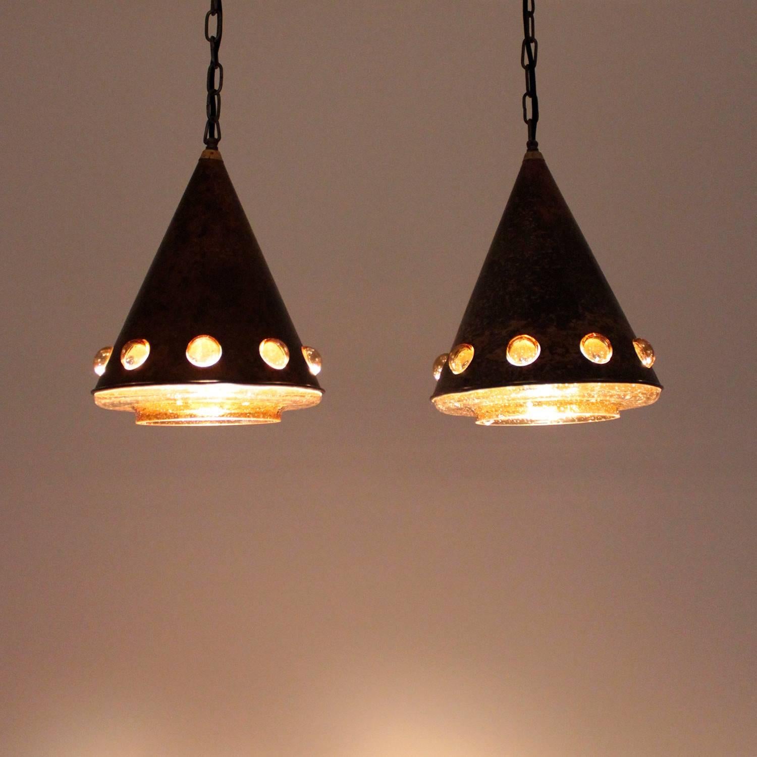 Copper and glass pendant pair by Finish designer Nanny Still-McKinney in the 1960s for the Dutch lighting producer Raak in Amsterdam - fantastic vintage pair in very good condition.

A pair of copper pendants with amber glass and a brass top.