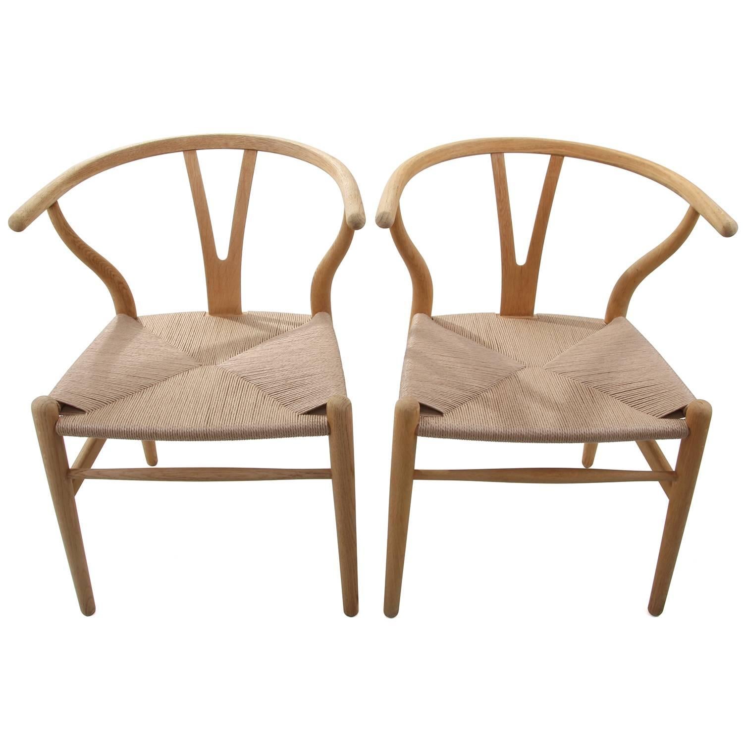 CH24 - WISHBONE CHAIRS by Hans J Wegner for Carl Hansen & Søn in 1949 - iconic Danish design - two oak Y-chairs, soap-treated and fitted with new woven paper cord seats. In excellent vintage condition!

The CH24 or WISHBONE Chair is by far the