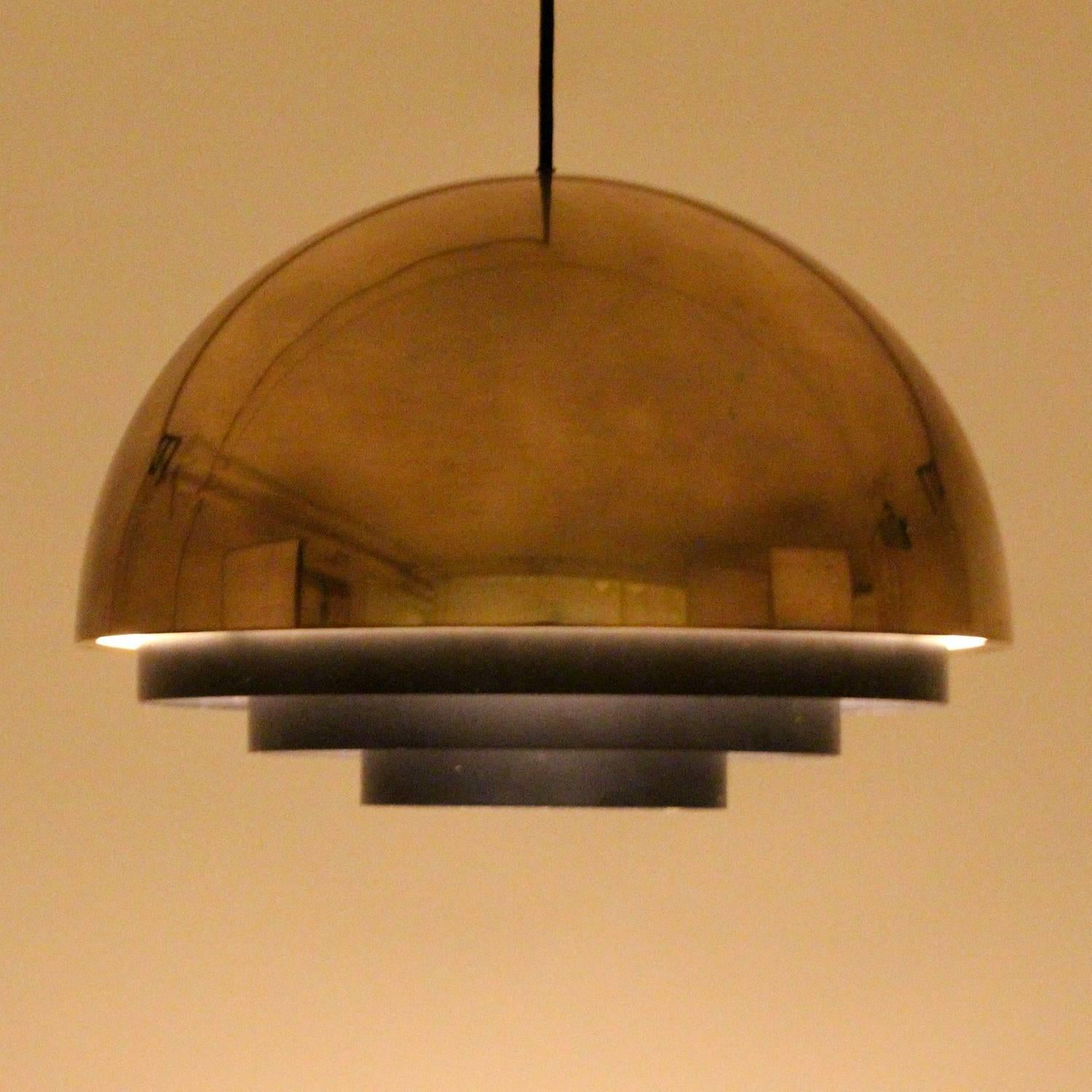 Milieu Maxi pendant designed by Jo Hammerborg for Fog and Mørup in the mid-1970s - beautiful large vintage gold-plated hanging lamp with black diffuser in good vintage condition.

A large gold-plated metal pendant shaped of a half circle with