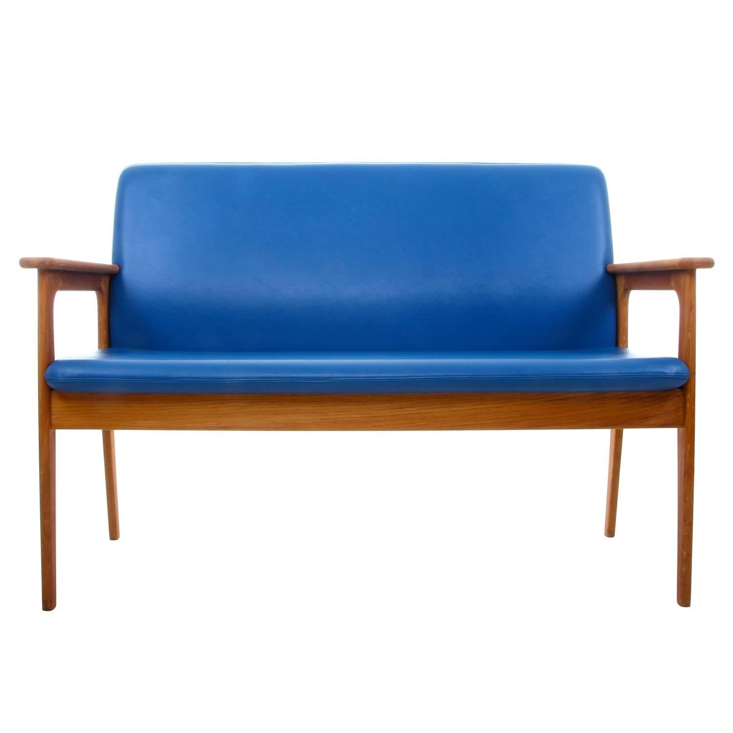 Two-seat sofa by Erik Buch, 1970s, elegant oil-treated oak couch with the original clear blue upholstery produced at O.D. Møbler - all in very good vintage condition.

Gorgeous two seat sofa comprised of oak frame with armrests, oil-treated which