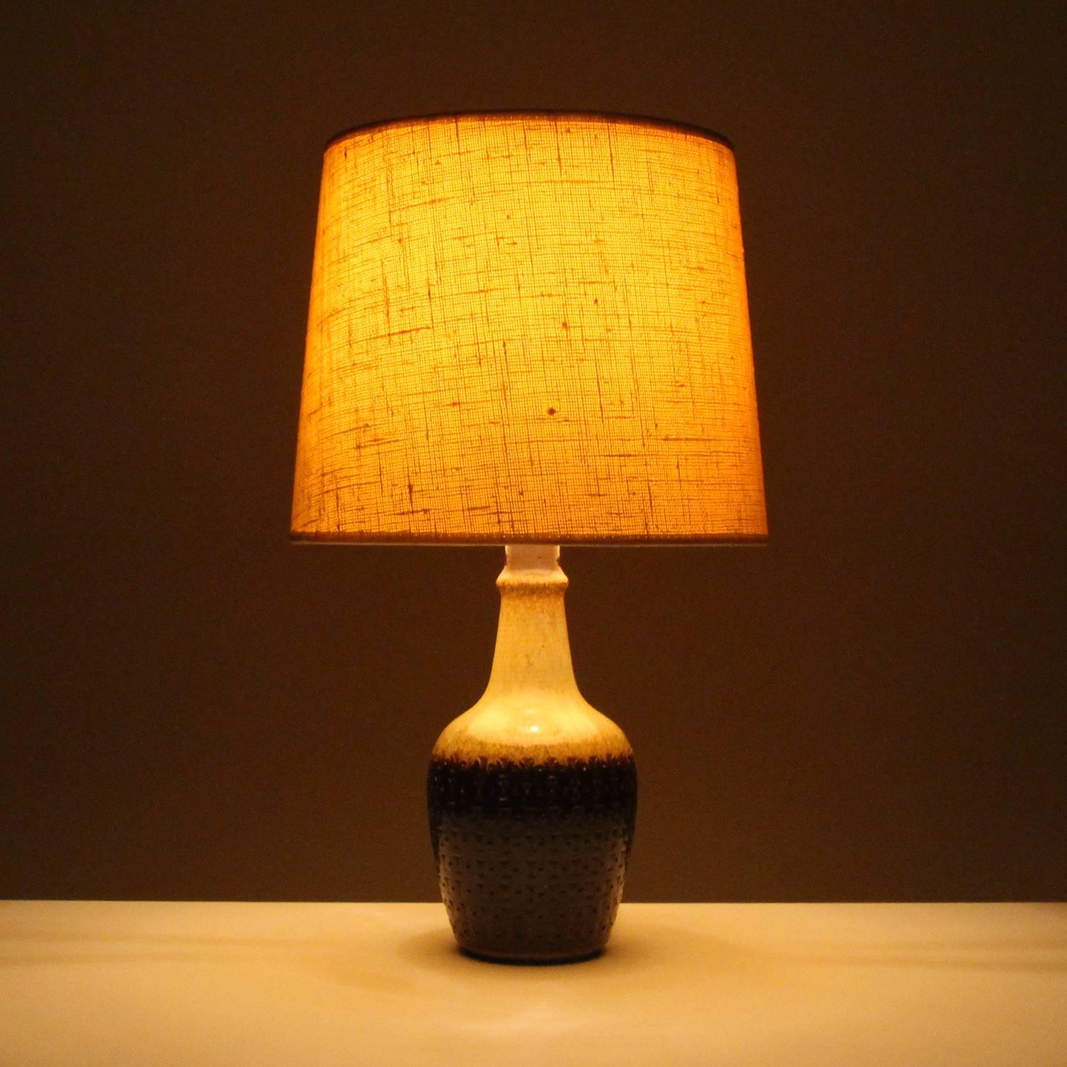 Ceramic table lamp, no. 3025 by Gerd Hiort Petersen for Søholm, Denmark in circa 1960, sand and dark brown glazed ceramic lamp stand with vintage fabric shade included, all in excellent vintage condition.

A beautiful ceramic table lamp with an