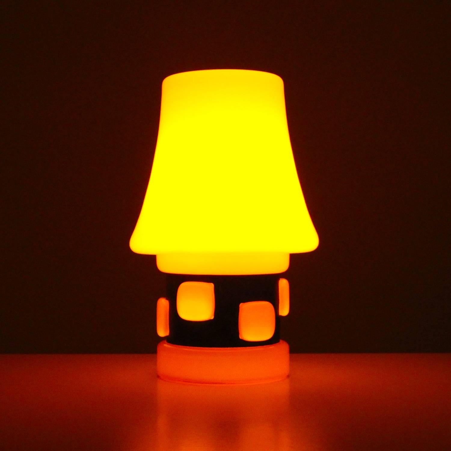 Orange table lamp by Danish lighting producer BA in the 1970s, fun and playful bright orange glass table light with dark gray metal in excellent vintage condition.

A very charming table lamp made up of bright orange glass with a dark gray metal