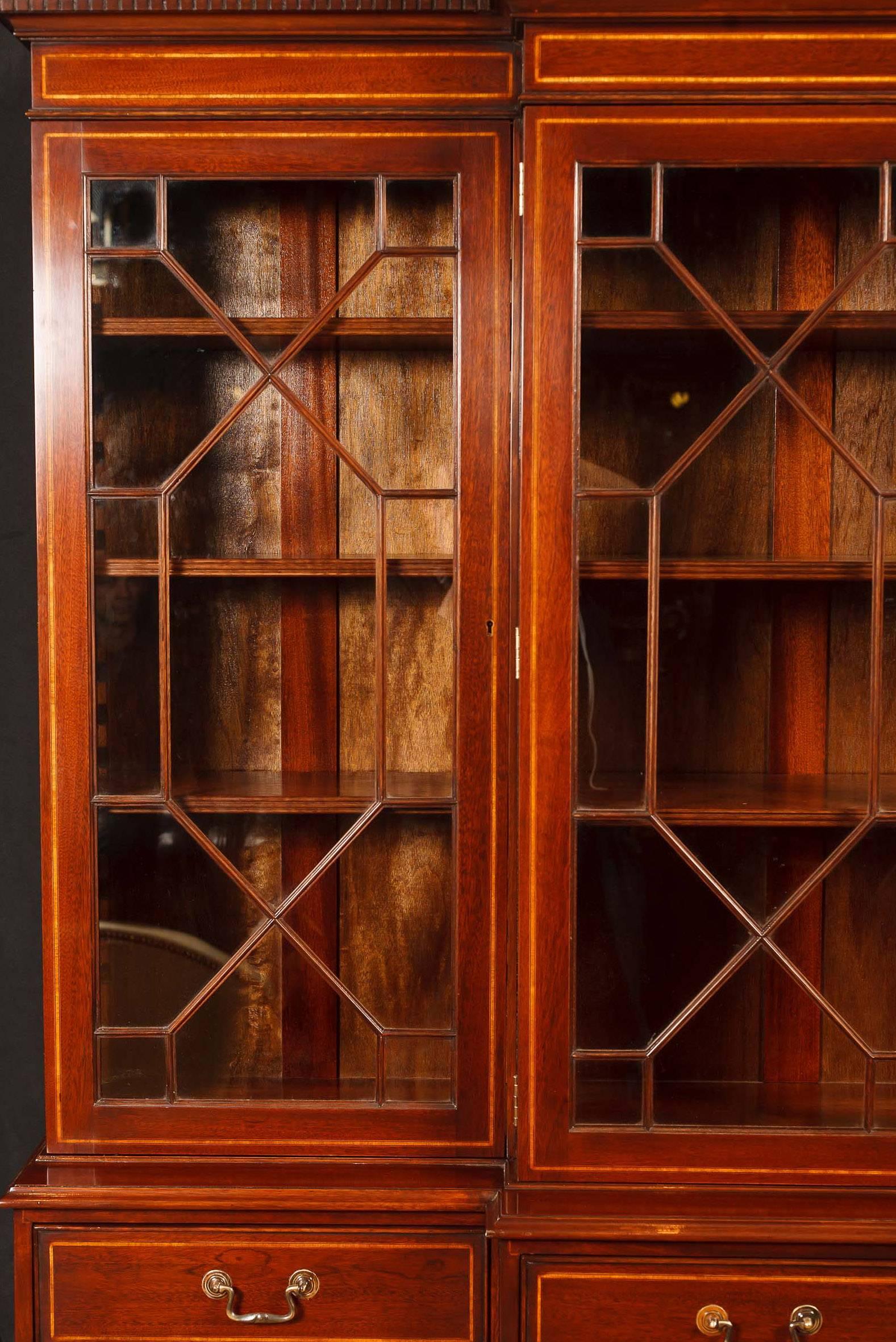 You are viewing a fantastic Sheraton style mahogany breakfront bookcase. The piece comes in two parts, the four door - four drawer base, and the glass fronted top. It's the perfect mix of aesthetic beauty and practical usefulness and will add a