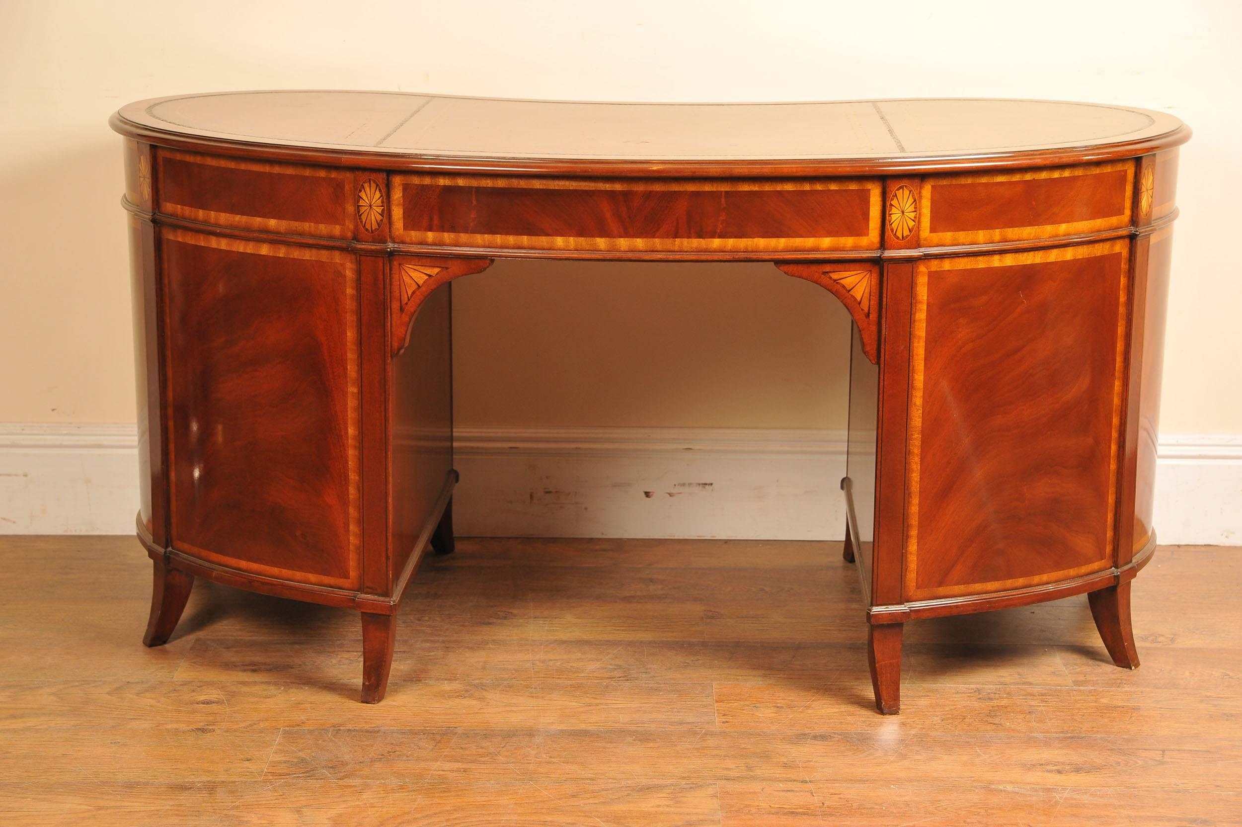 You are viewing a gorgeous kidney bean shaped desk in the English Regency style and handcrafted from the finest, sumptuous mahogany. The desk is covered in a lovely brown tooled leather with gold leaf banding to the perimeter and it is very