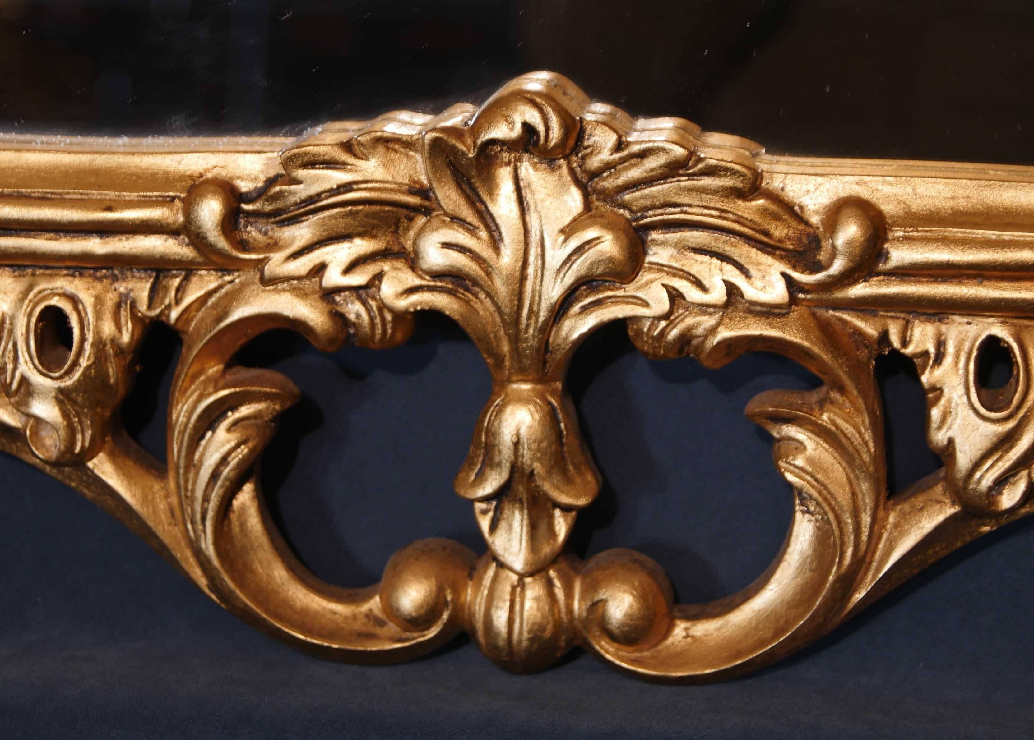 Wonderful English Chippendale style gilt mantel mirror.
Florid giltwood frame in the Rococo manner.
Piece is hung landscape, great above a firelplace of couch.
Glass is clear and blemish free.
Offered in great condition, ready for home use right