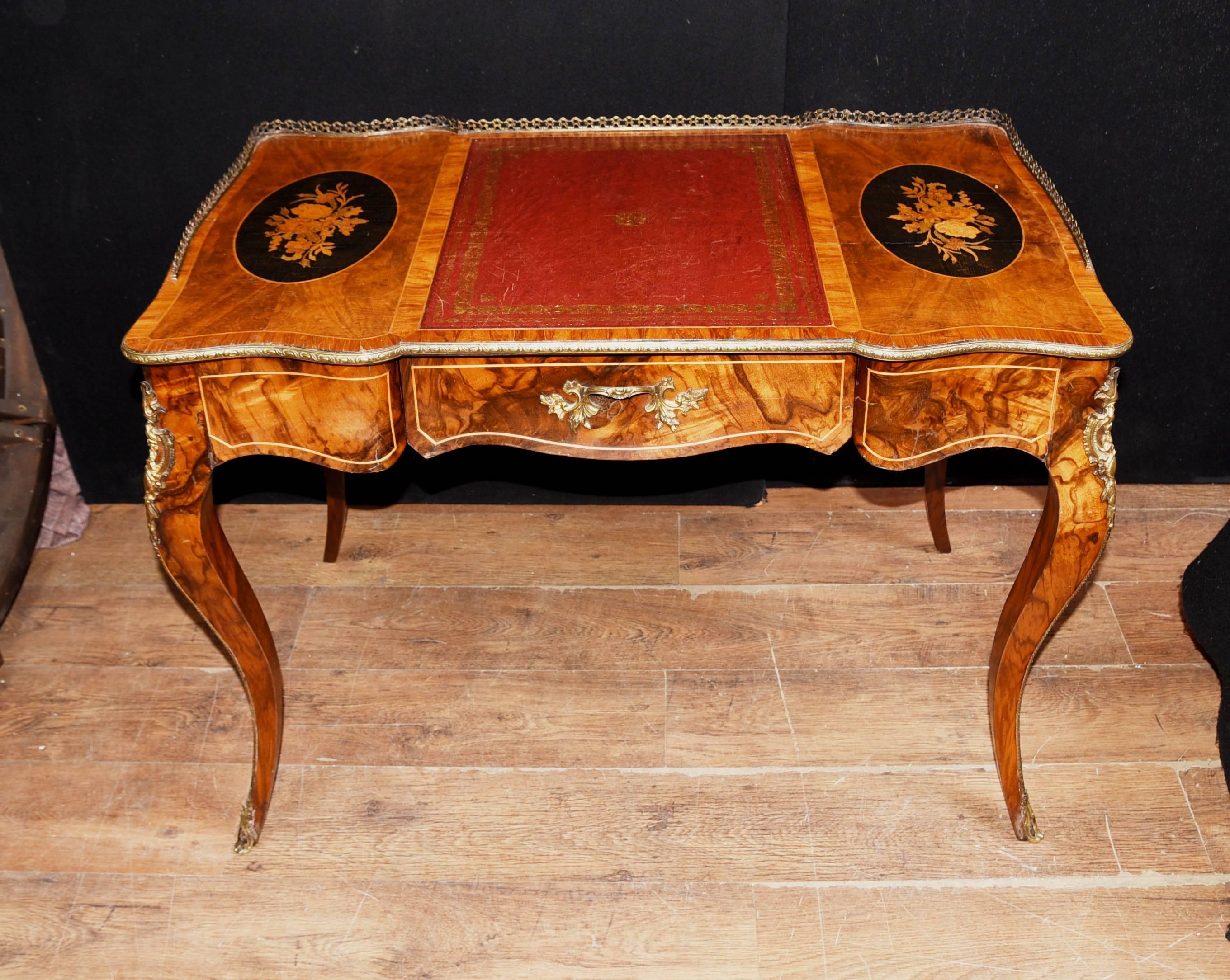 Highly charming French Empire writing table or bureau plat
handcrafted from walnut with ebonized plaques and floral inlay to the top
Ormolu fixtures include sabots, trim and intricate gallery
Great for a home office set up, single red tooled