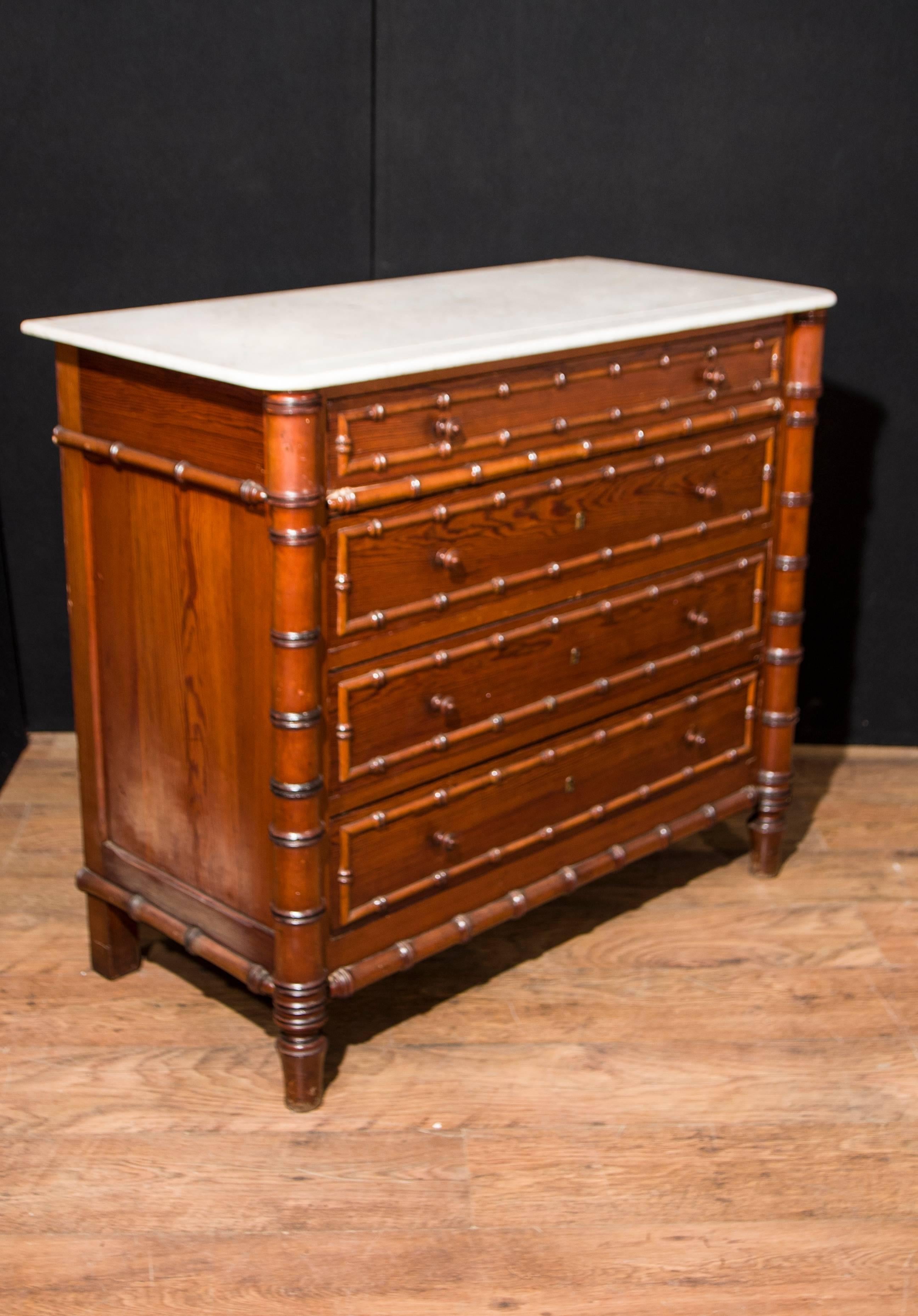 Gorgeous antique French Regency chest of drawers with faux bamboo look.
We date this wonderful commode to circa 1890.
Very trendy look with faux bamboo crafted from pine.
White marble top is smooth and chip free.
Four drawers so ample storage