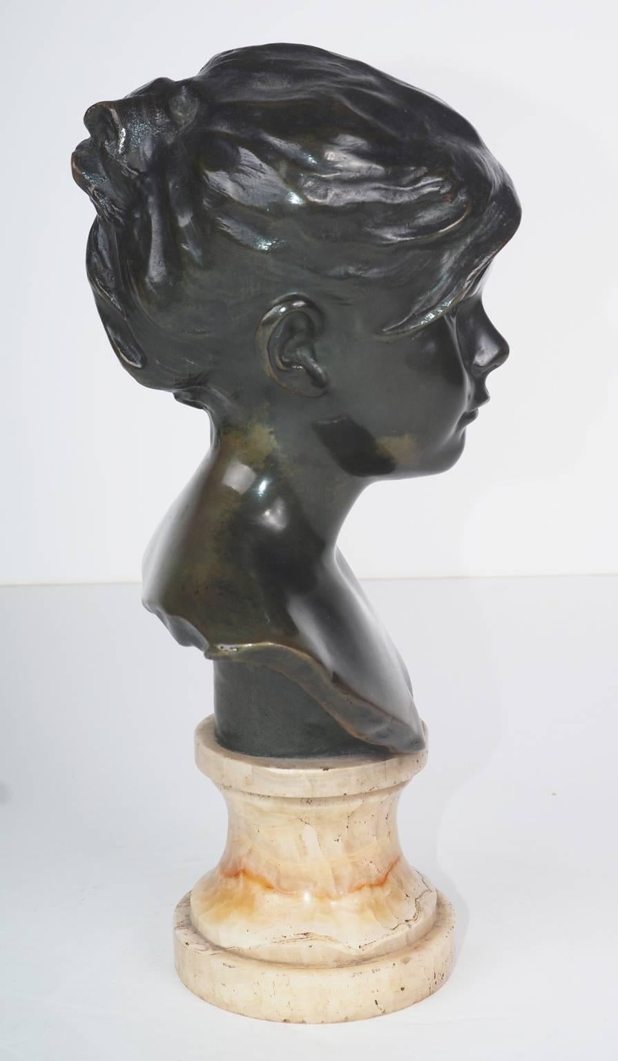 Fine bust of a young girl in a realistic style with a deep green patina.