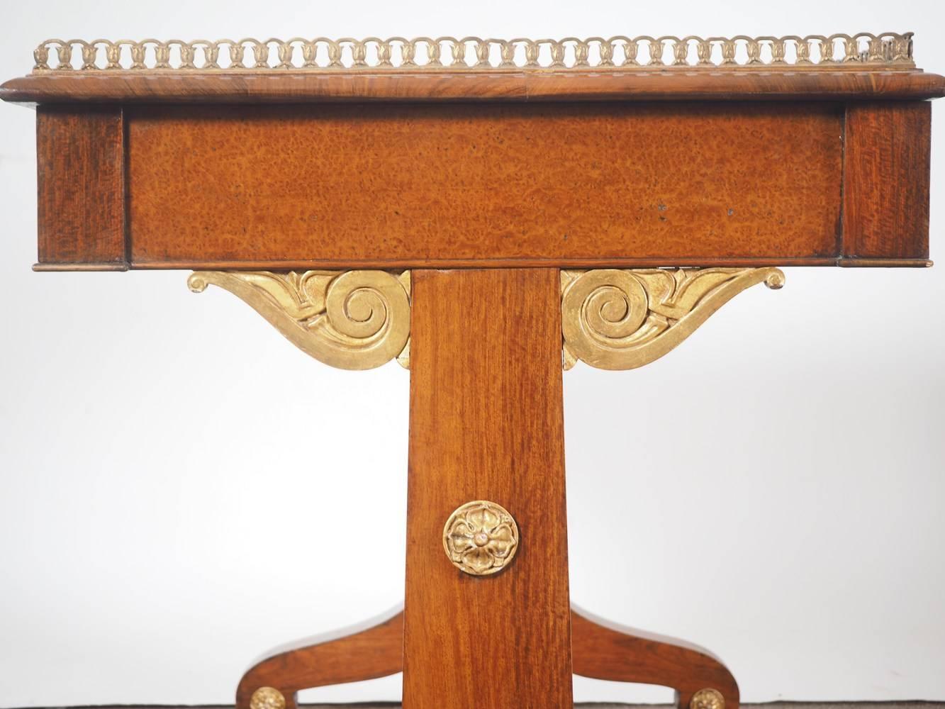 Fine quality Regency period writing table made from amboyna and padouk with parcel-gilt enrichments and ebony knobs, circa 1820.