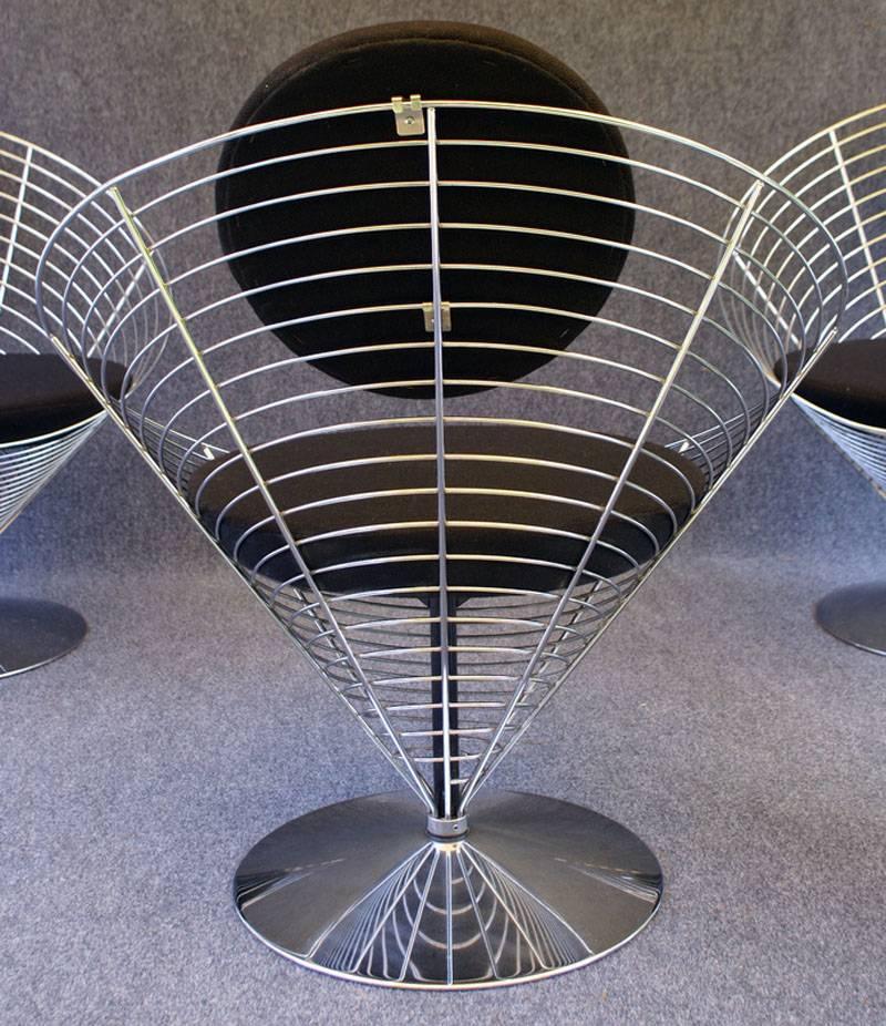 Very nice set of four swivel wire cone dining chairs by Verner Panton for Fritz Hansen in chrome with black upholstery.