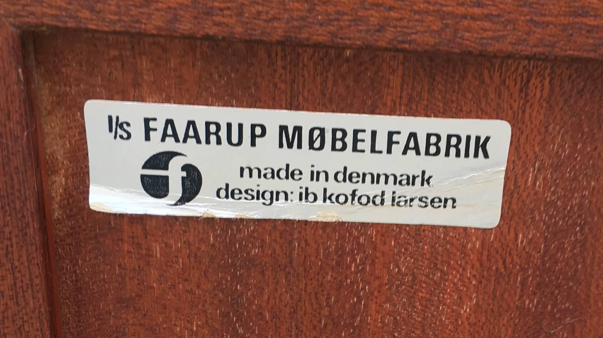 Long rosewood sideboard/credenza with four doors and four drawers, the left door opening to reveal a set of linen trays by Ib Kofod-Larsen for Faarup Møbelfabrik. All in very good condition