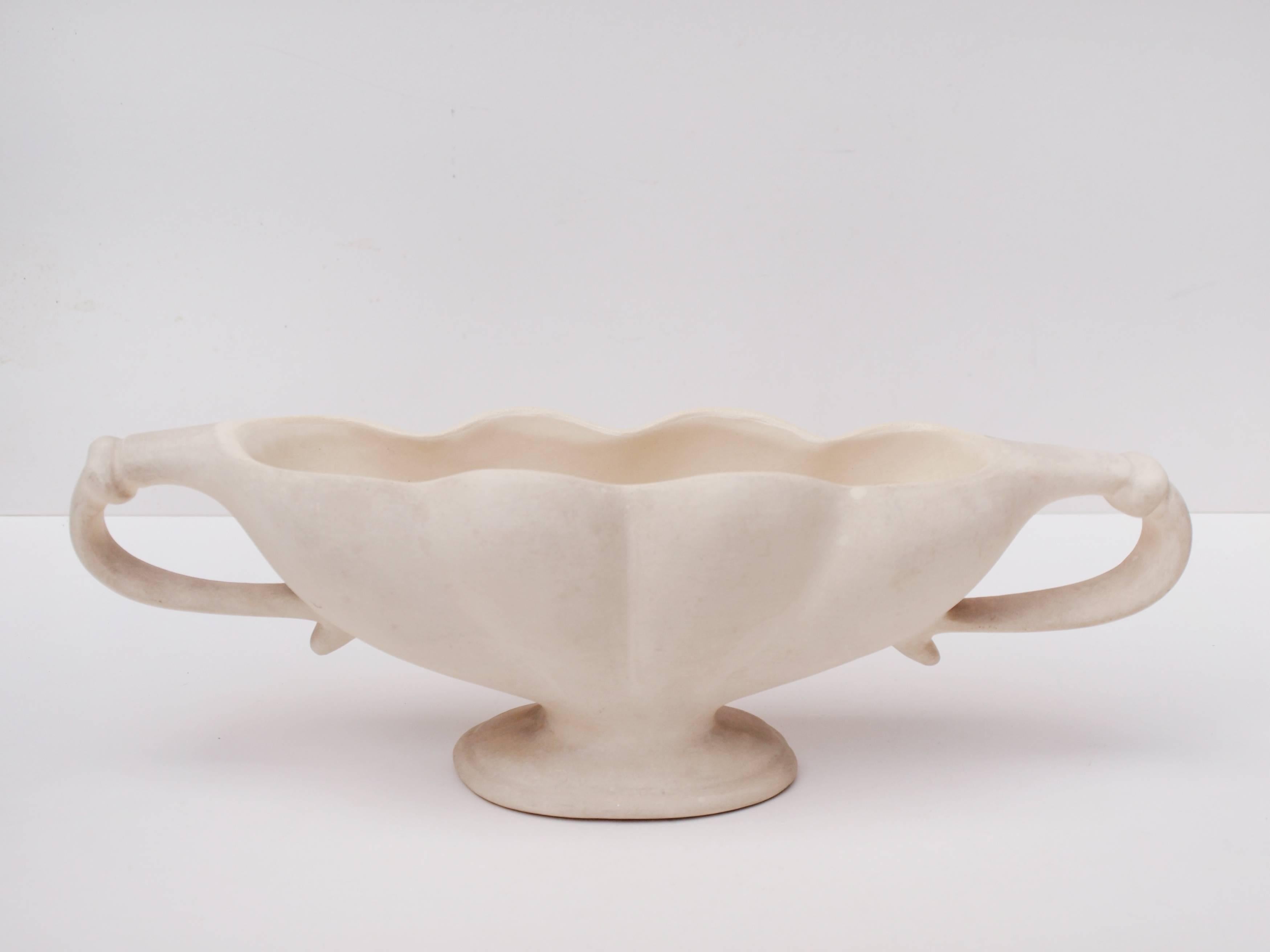Anl ivory glazed twin-handled mantel vase designed by the influential florist constance spry for Fulham Pottery. The exterior of the vase is matte, with a gloss interior. Stamped to the base with Fulham Pottery.

The undulating shape of this vase