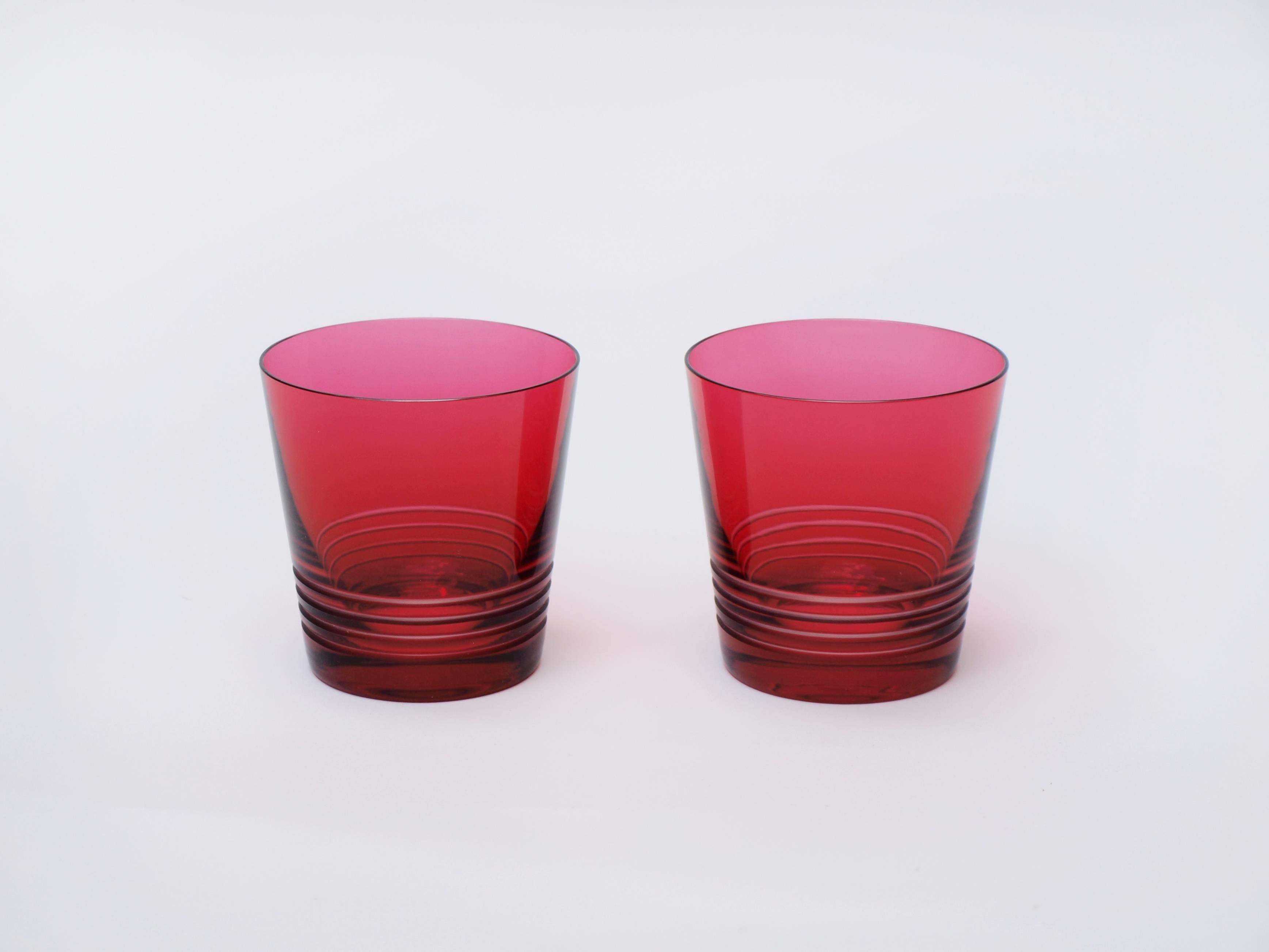 This stylish pair of red tinted crystal whisky tumblers designed by Hermés, are slightly fluted with a linear etched design towards the weighted base.

Diameter at top: 10cm diameter at base 7.5cm, height 10cm.