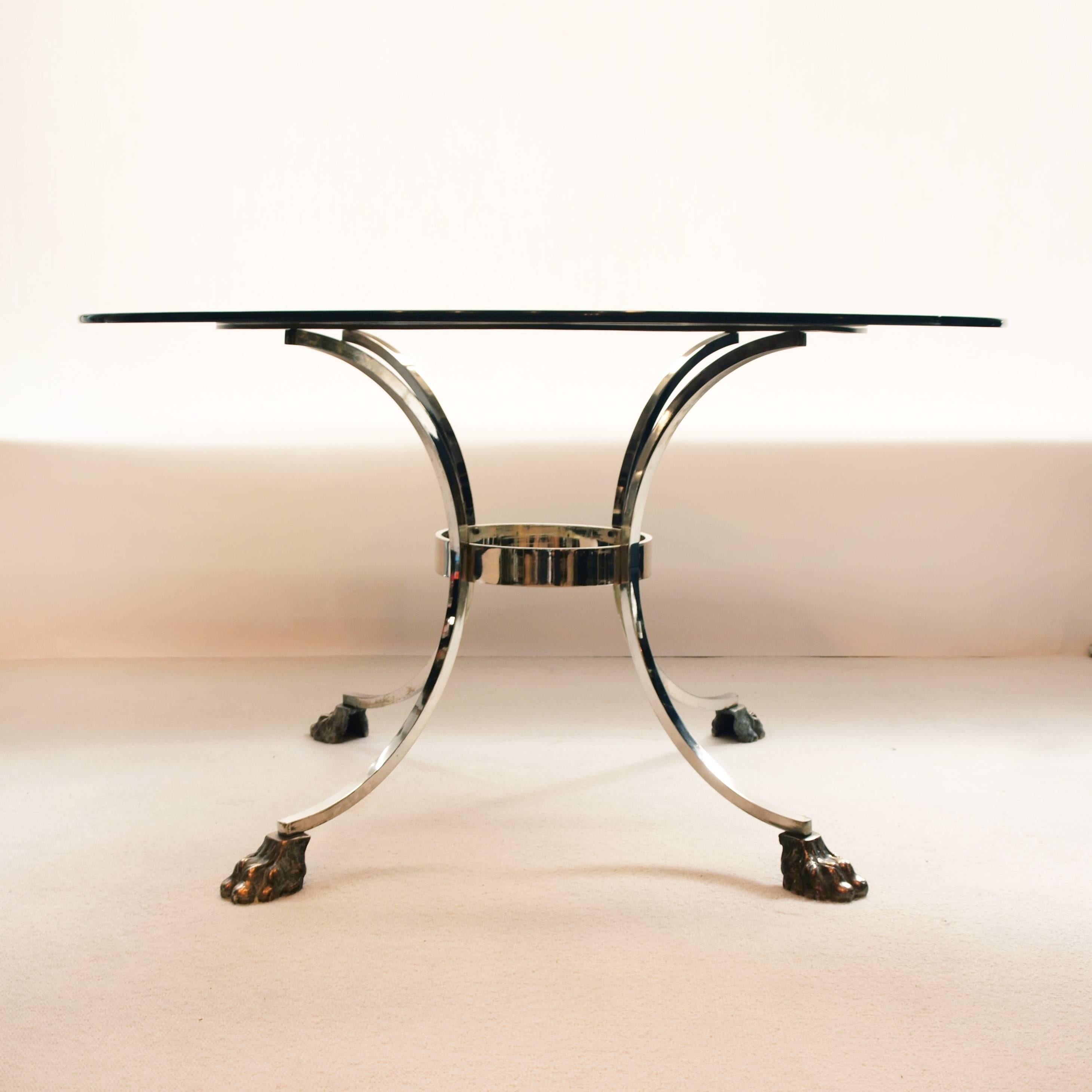 A stunning early 1970s dining table chrome and brass base resting on Regency style lion paws feet with smoked glass top.