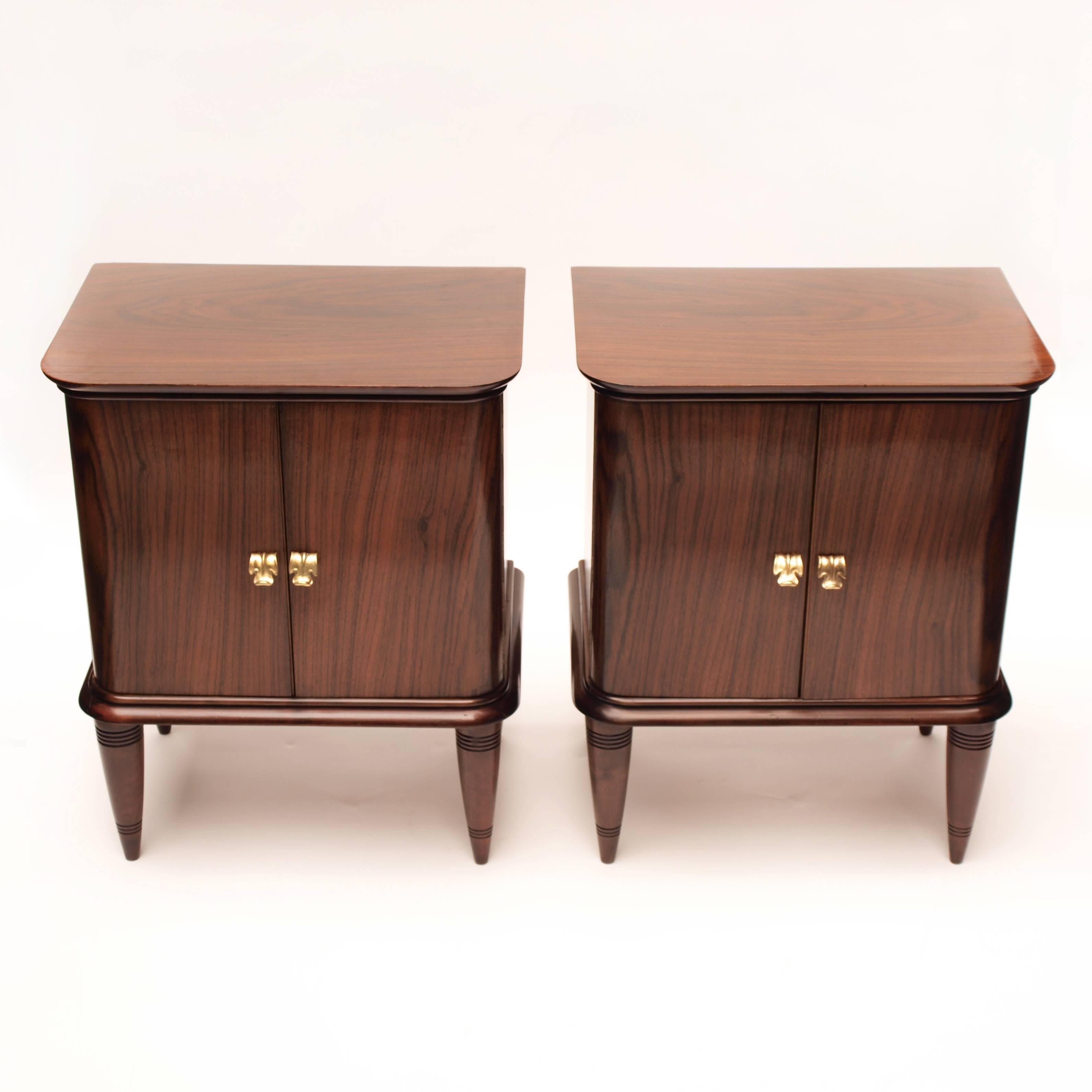 Milanese architect and designer Paolo Buffa (1903-1970) is a master of sophisticated, inventive classicism.
His thoughtful simplicity of design is embodied in this fine pair of nightstands finished in a smooth rosewood veneer and adorned with brass