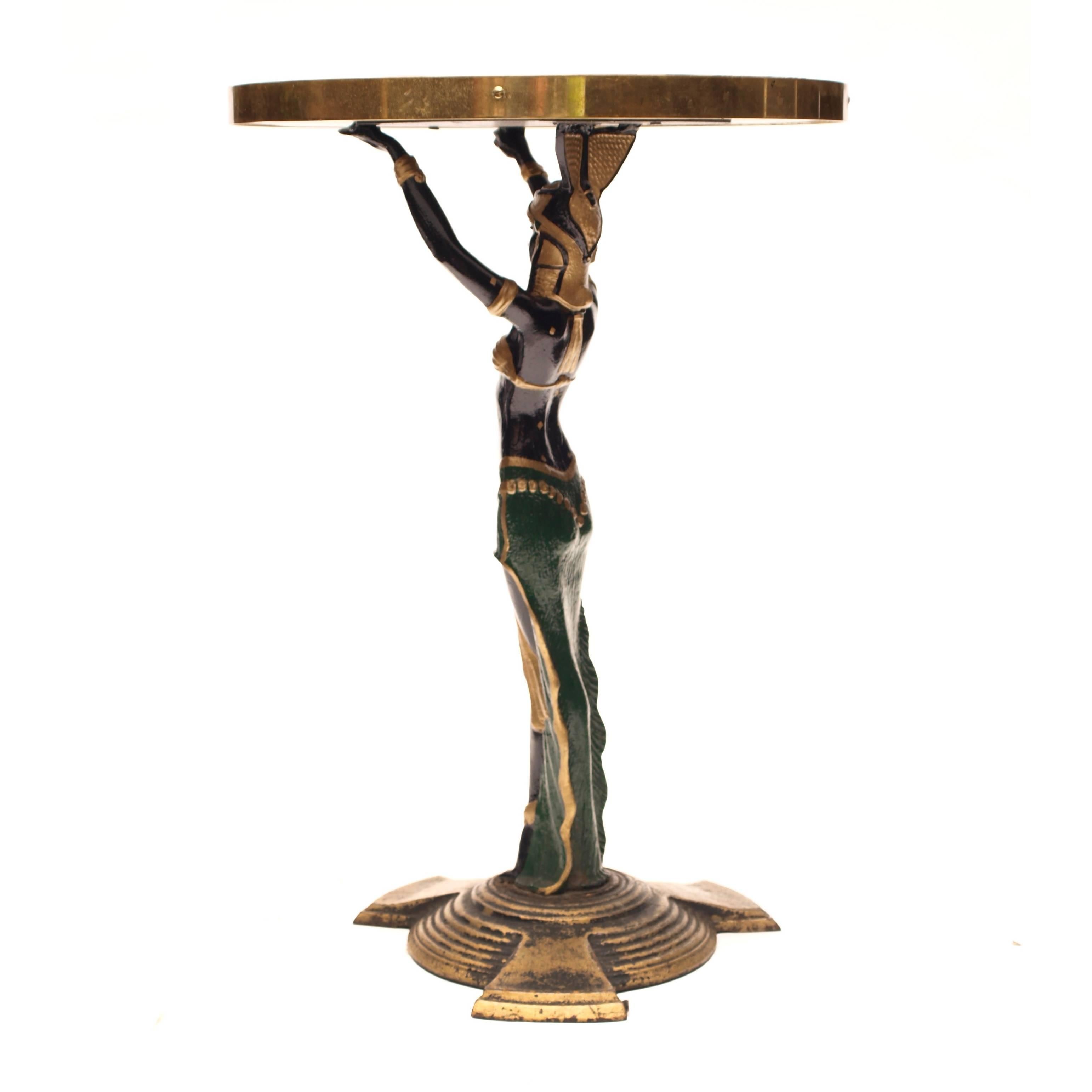 A pair of 1920s Art Deco cast iron table stands, with a later addition of black Formica and brass banded tops. 

Sourced from a Vaudeville-style music hall in the north of England, these naughty yet beautifully ornamental tables are an example of