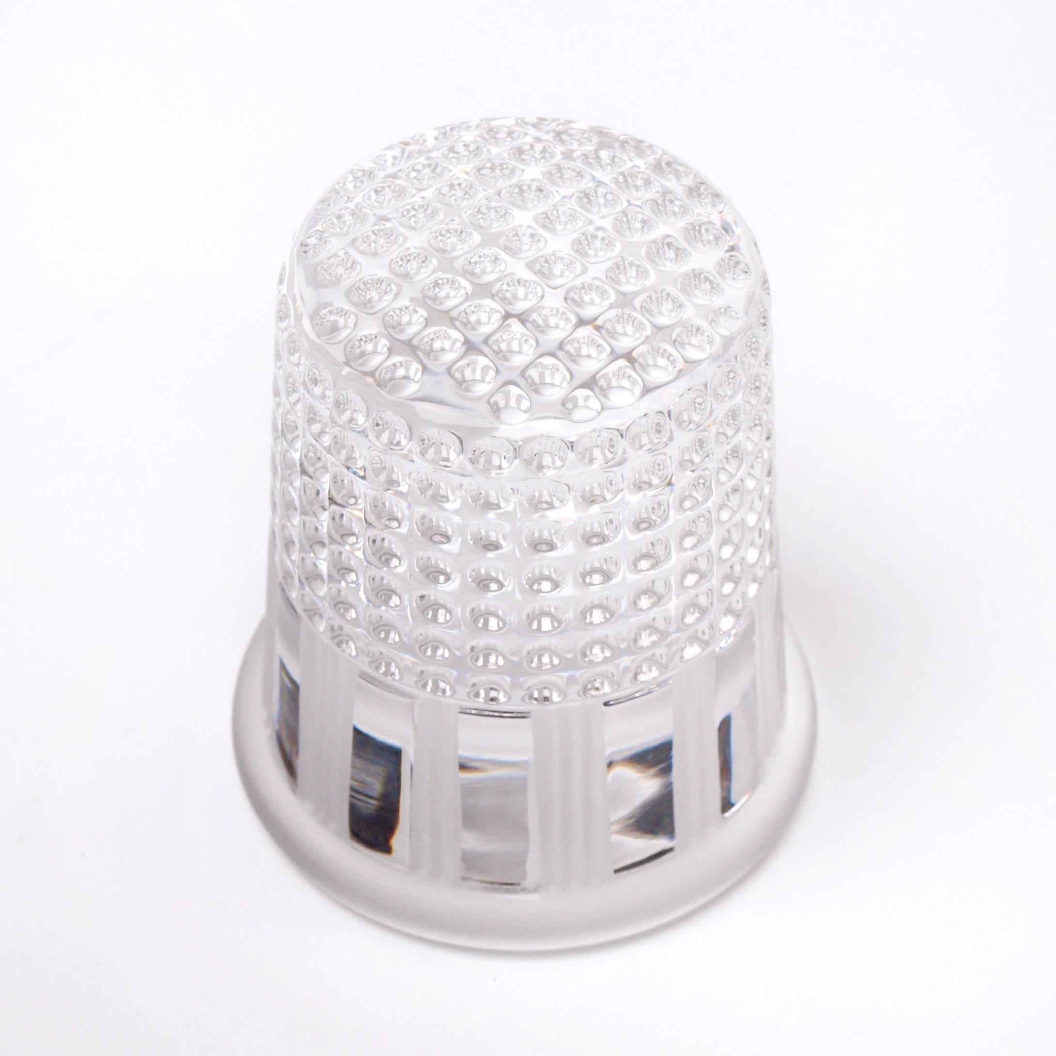 A 1970s paperweight by Christian Dior for French crystal glass manufacture, Crystal Au Plomb. The paperweight features a glossy perforated surface towards the top, imitating that of a thimble, with an alternating frosted scalloped design surrounding