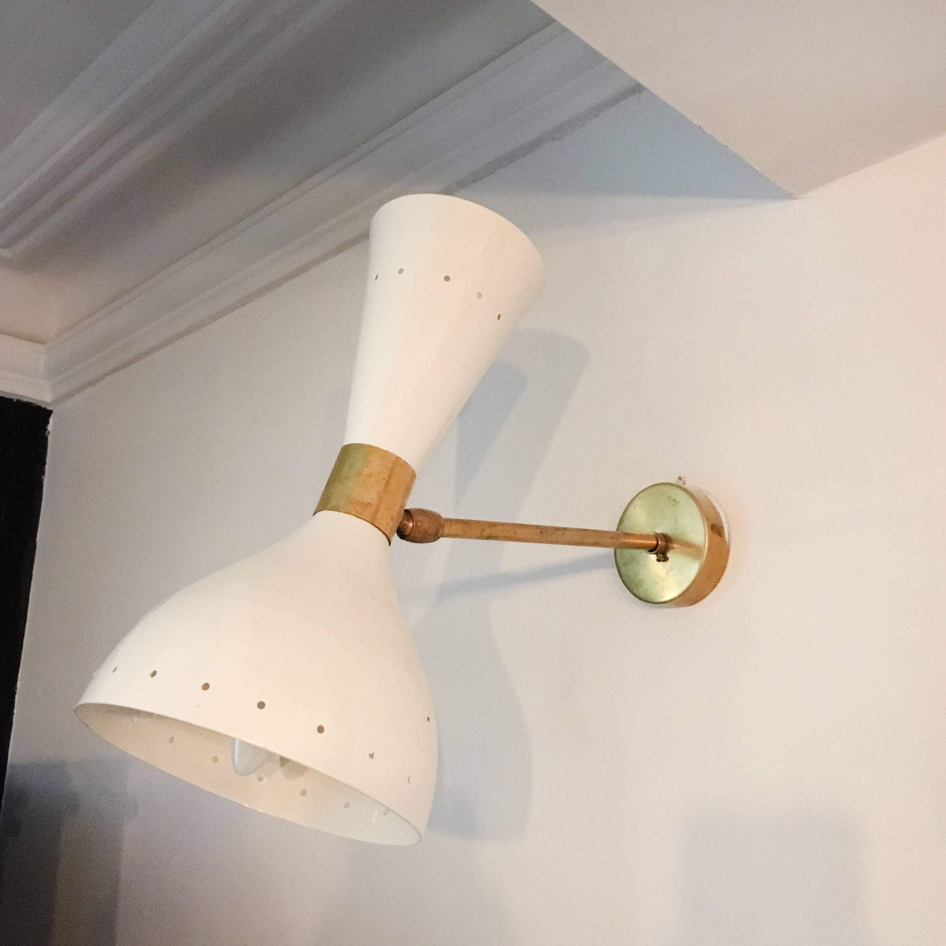 These elegant Mid-Century Italian wall lights each comprise of a diablo lampshade with both up and down lights. Each lamp is connected to their stem with a ball and socket join, allowing easy adjustments to the angle of the light.