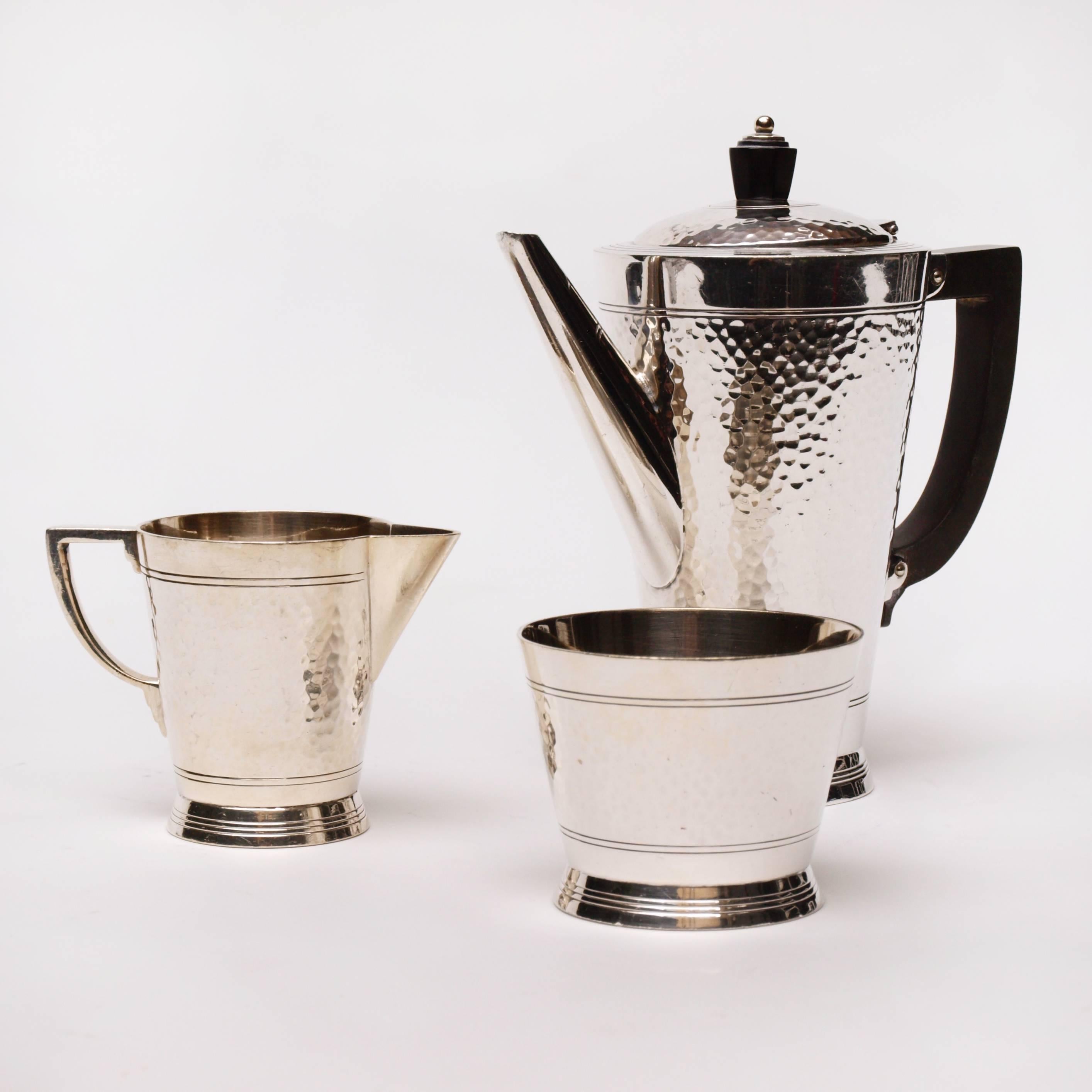 An exquisite three-piece Art Deco coffee set designed by Keith Murray for Mappin and Webb. The silver plated set comprises of a small sugar pot, milk jug and two-cup teapot. All three pieces are embellished with etched pin stripes around the