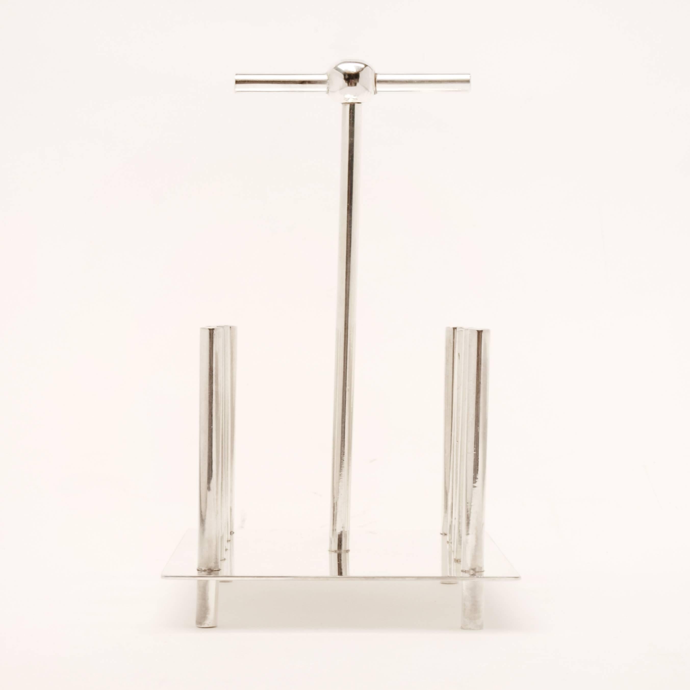 Although modernist in appearance, this silver plated toast rack is based on a Christopher Dresser design from the late 1800s, featuring 10 simple silver posts to hold 4 slices, with a taller central post for the handle. A striking Minimalist