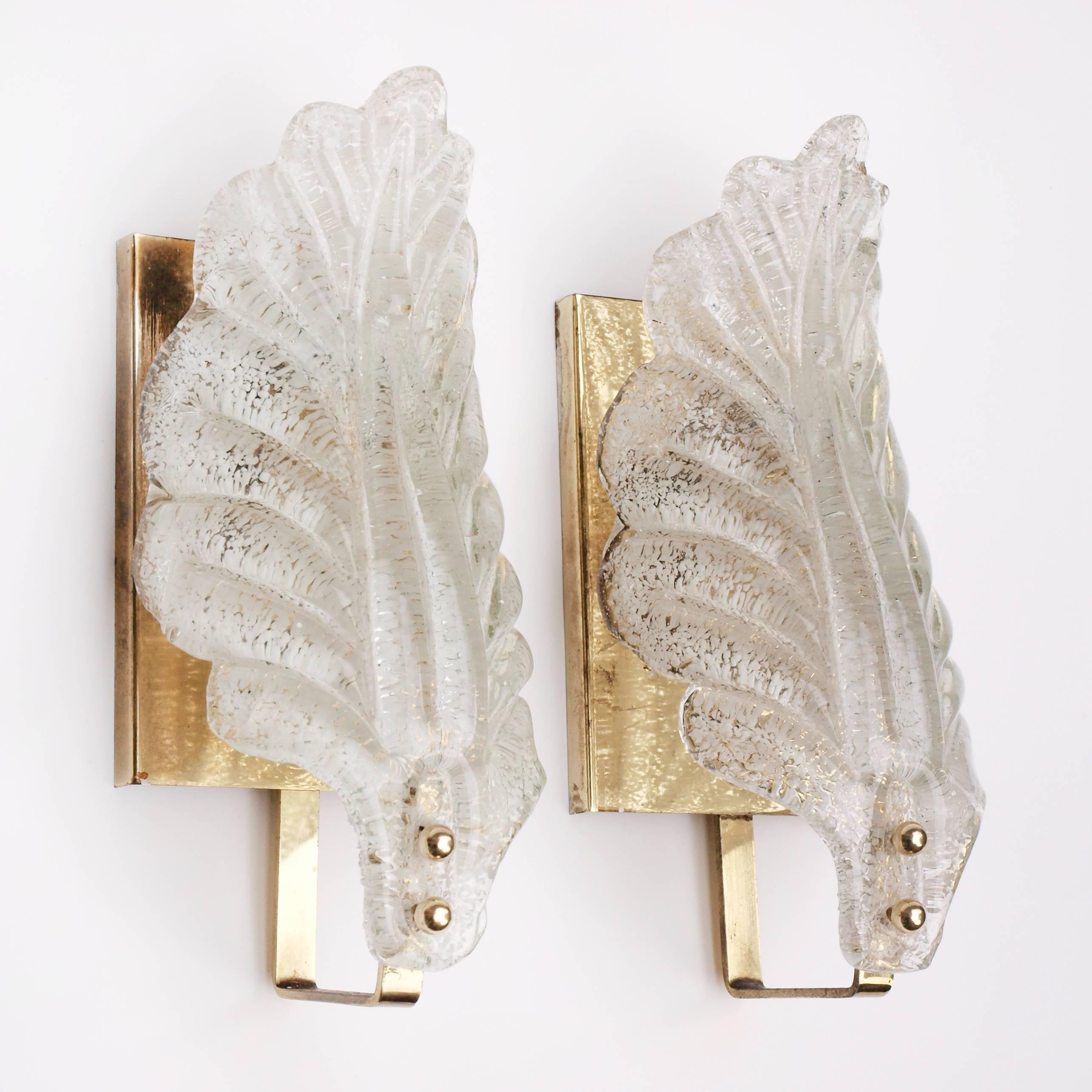 A pair of 1950s Murano leaf shaped sconces with a white speckled pattern to the glass. The glass leaves are held to brass plates with two spherical brass fixings.