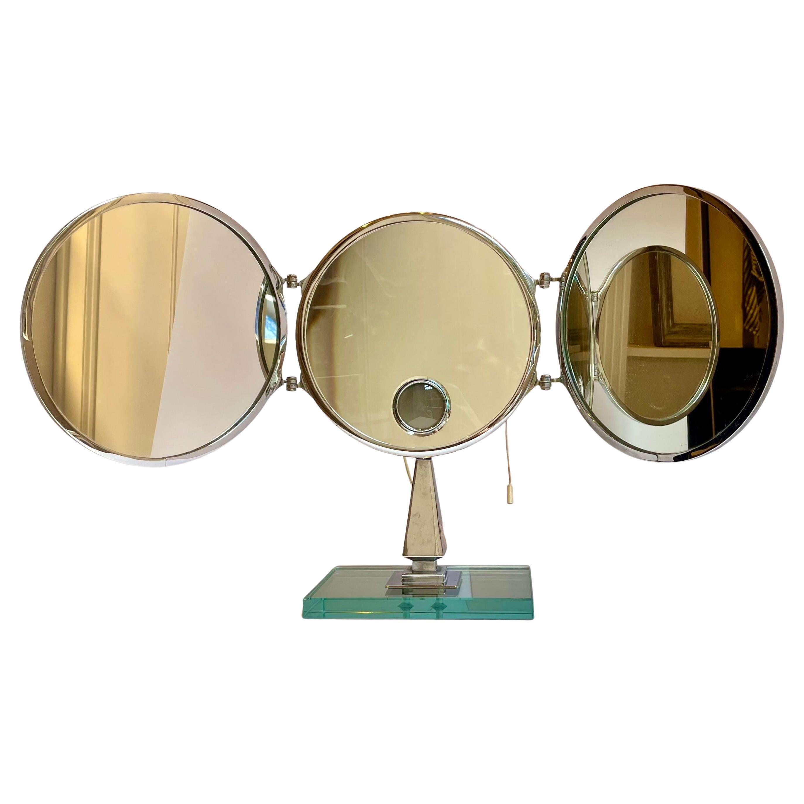 A 1950s triptych vanity magnifying mirror in nickel on a thick glass base by the French Company Brot known for quality and craftsmanship
Brot revolutionized the industry with the introduction of the triptych mirror in 1875, followed by the first
