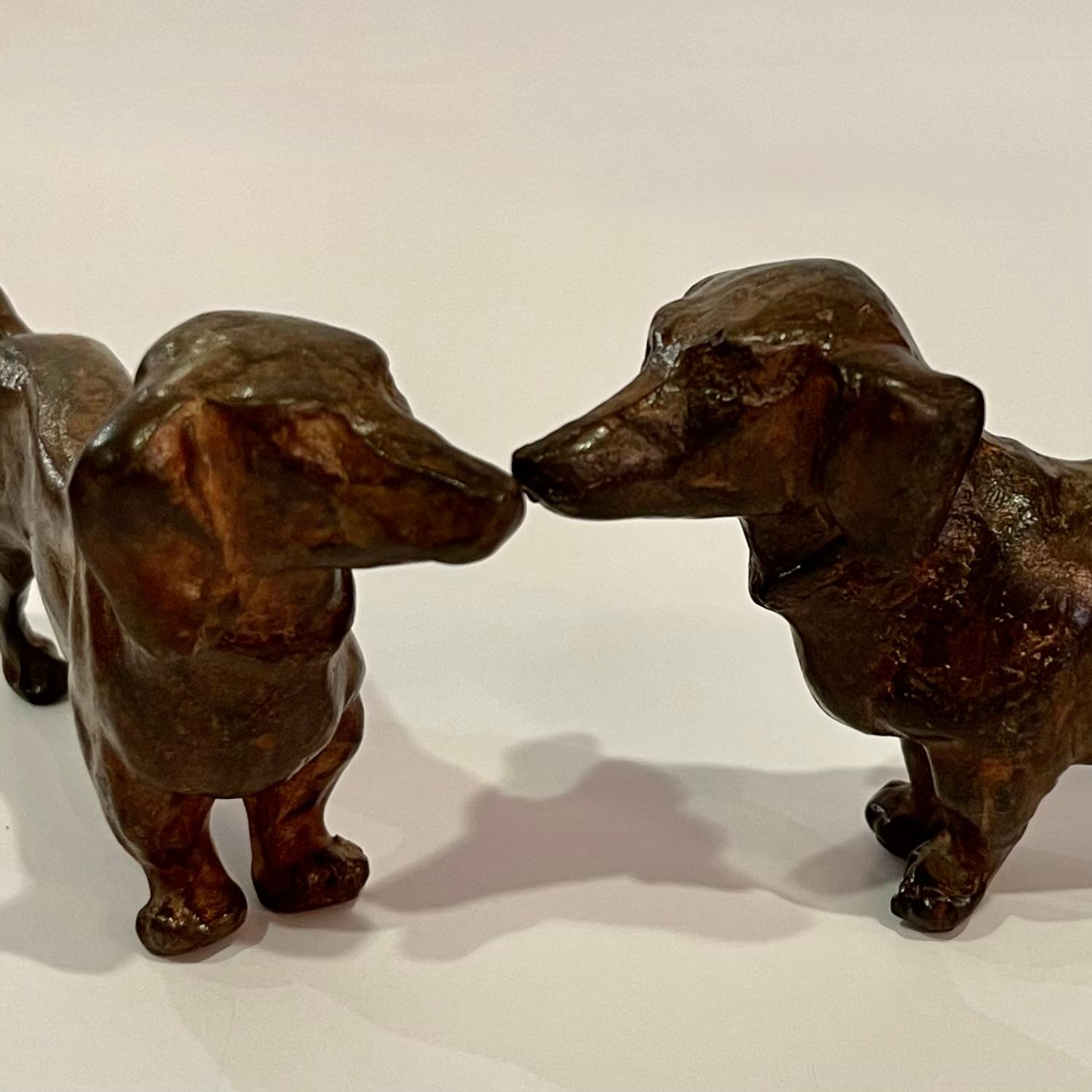 A Pair of adorable 'dachshunds' sculptures in patinated bronze with foundry stamps by Pierre Chenet known for his animal sculptures.