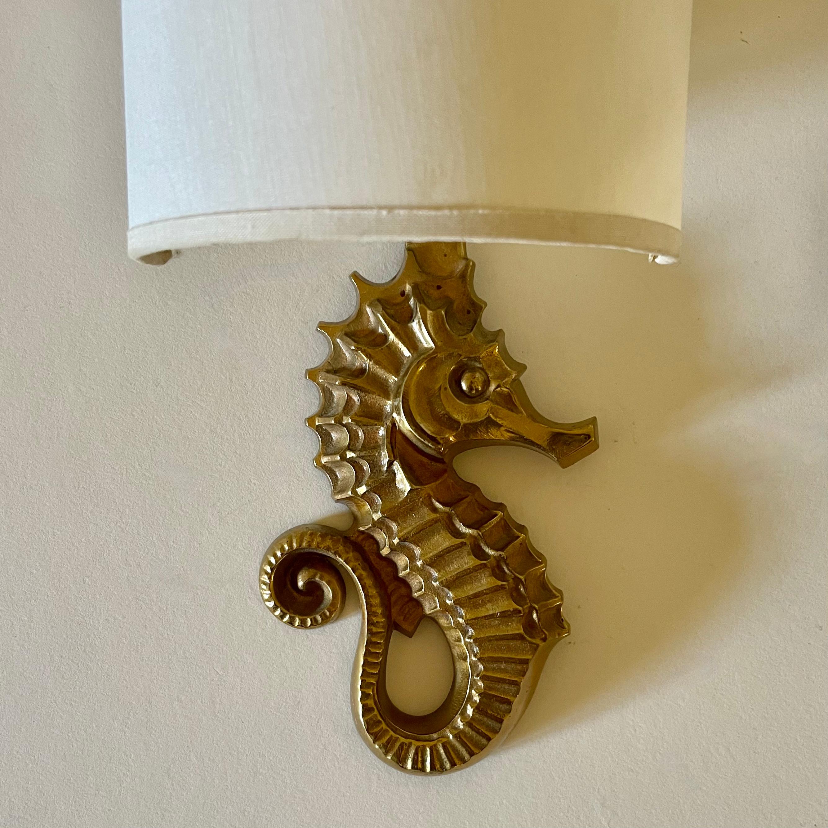 
Une belle paire de  Appliques murales en bronze doré hippocampe par Guillemard circa 1940.
Au dos, le nom de Guillemard a été apposé.
Une autre paire est disponible avec une patine dorée légèrement plus claire. 


