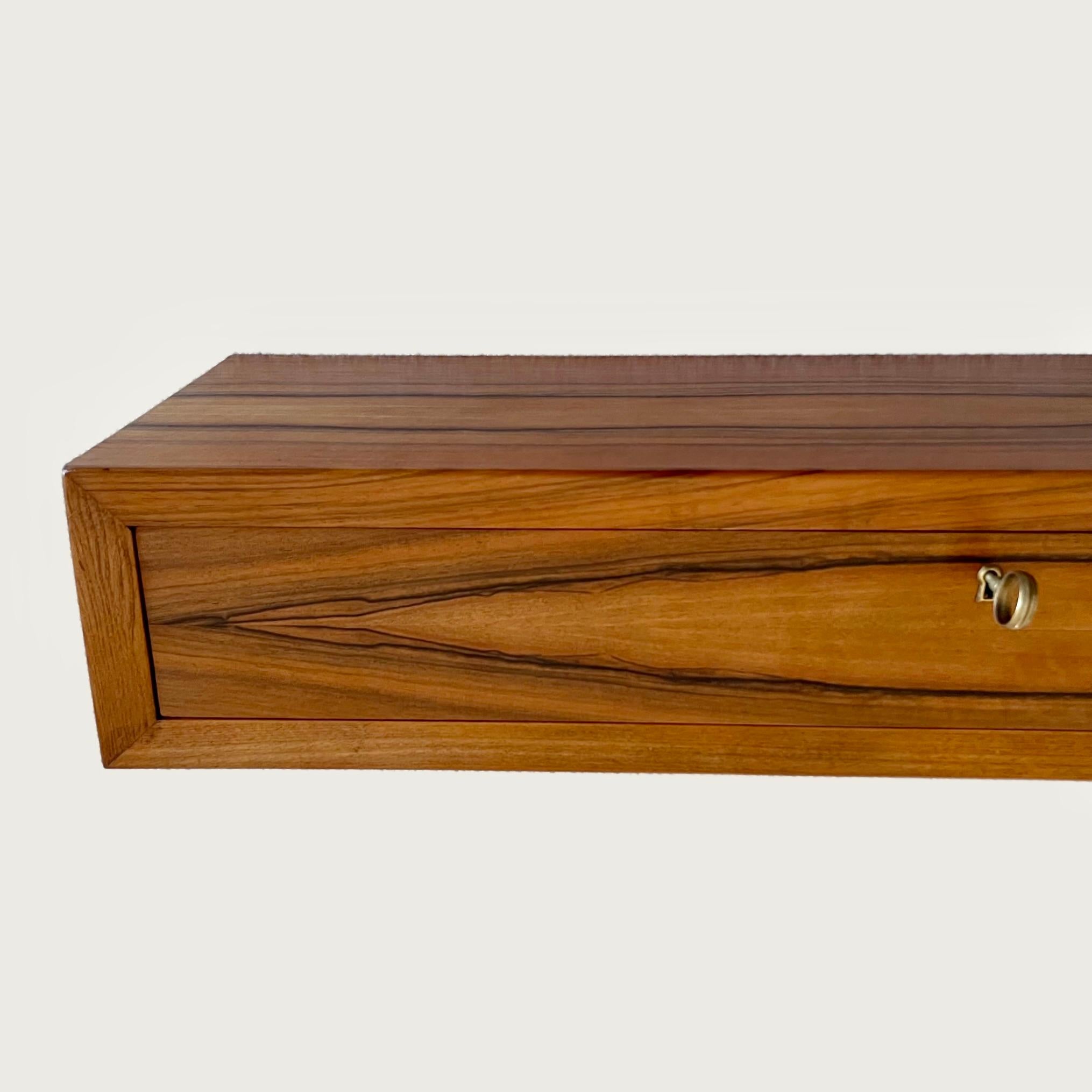 A wall mounted floating console attributed to Piero Bottoni circa 1940, finished in beautifully figured walnut veneer with a single drawer and original oversized circular brass key. 