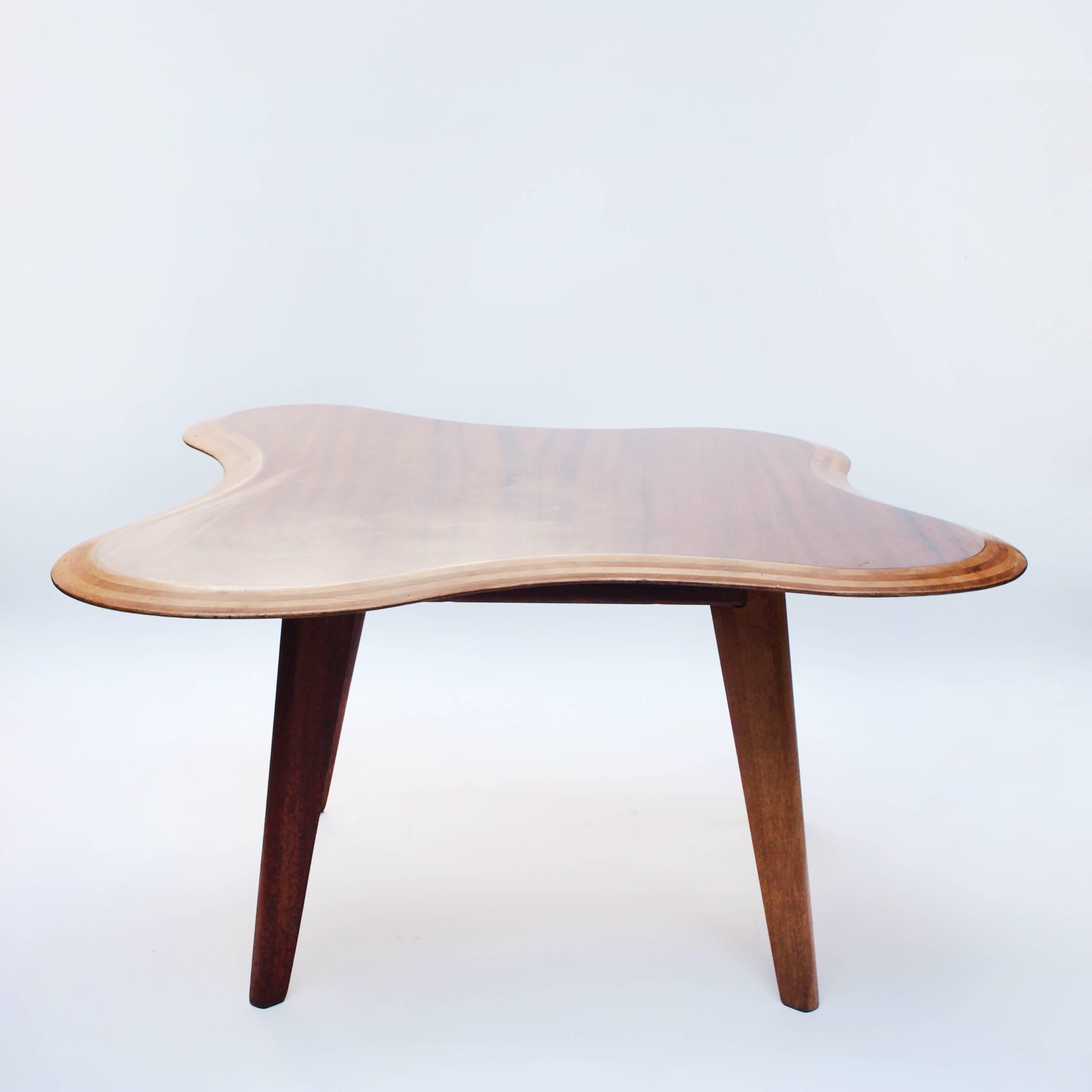 A beautifully shaped table, designed by Neil Morris for Morris & Co, Glasgow. Combining Honduras mahogany, Betula wood and curved bevelled edges which expose the striped wood lamination, circa 1950.


 