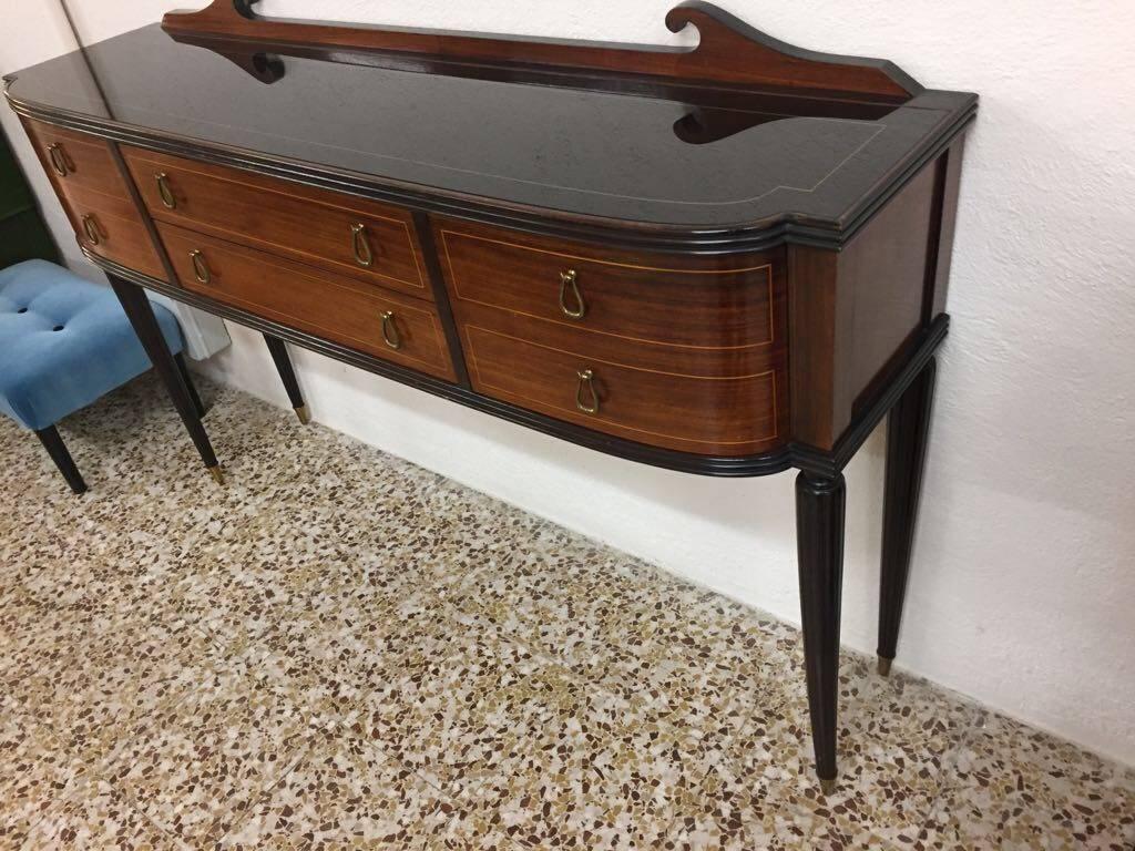 A Italian fruitwood and brass buffet by Paolo Buffa. With two central drawers and two cupboards.
Top in black and gold glass.
  