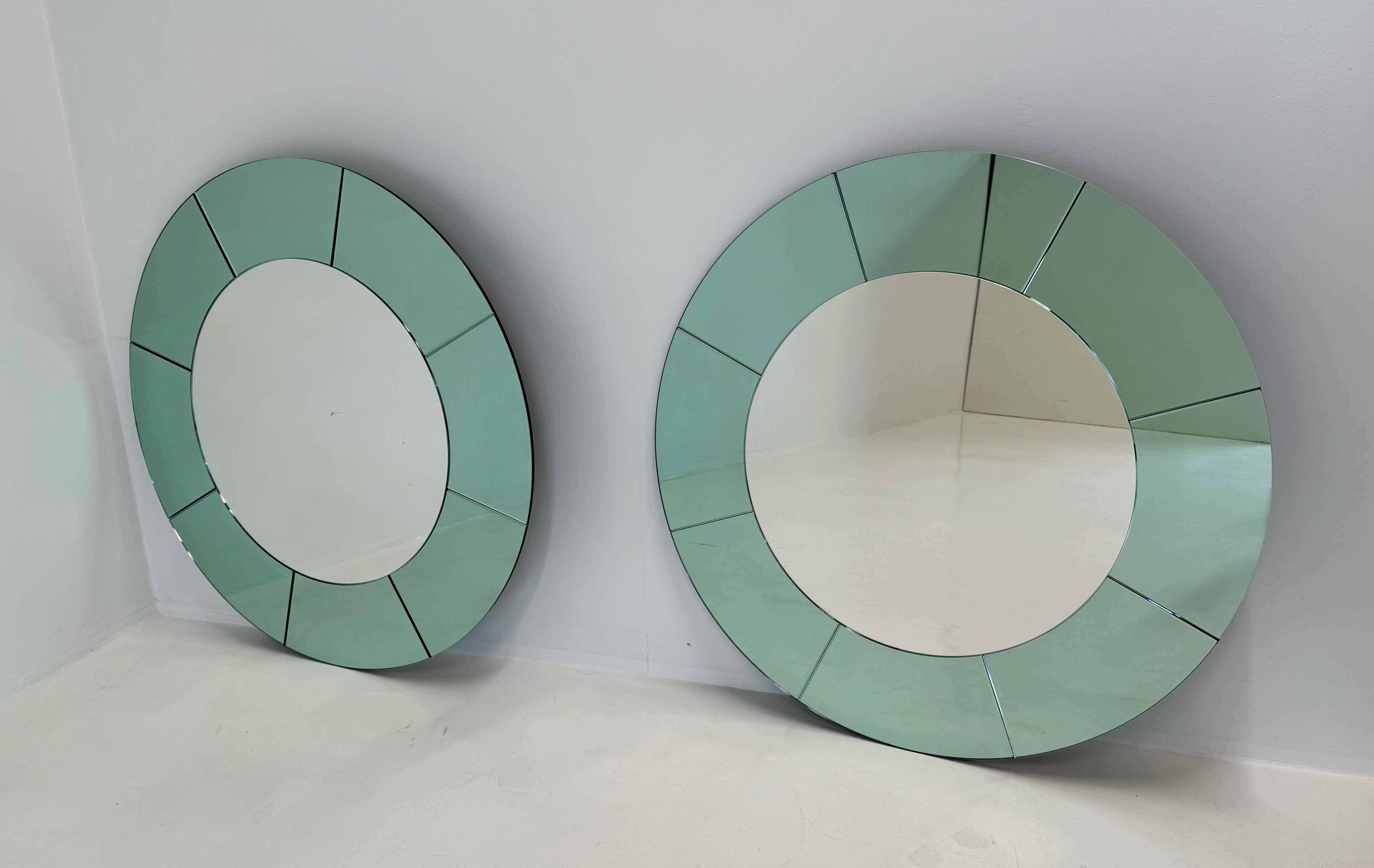 Cette paire de miroirs muraux sophistiqués a été fabriquée en Italie et présente un design raffiné qui rappelle fortement l'esthétique emblématique de Fontana Arte. Les cadres sont entièrement fabriqués en verre miroir vert rare, un matériau