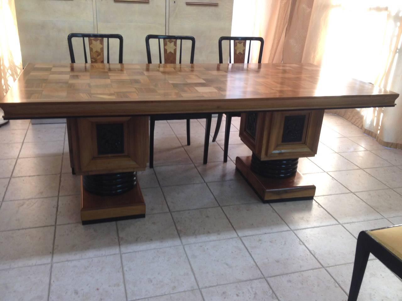 This Art Deco table was produced in France. It is made from solid walnut and has an inlaid top and carved legs.