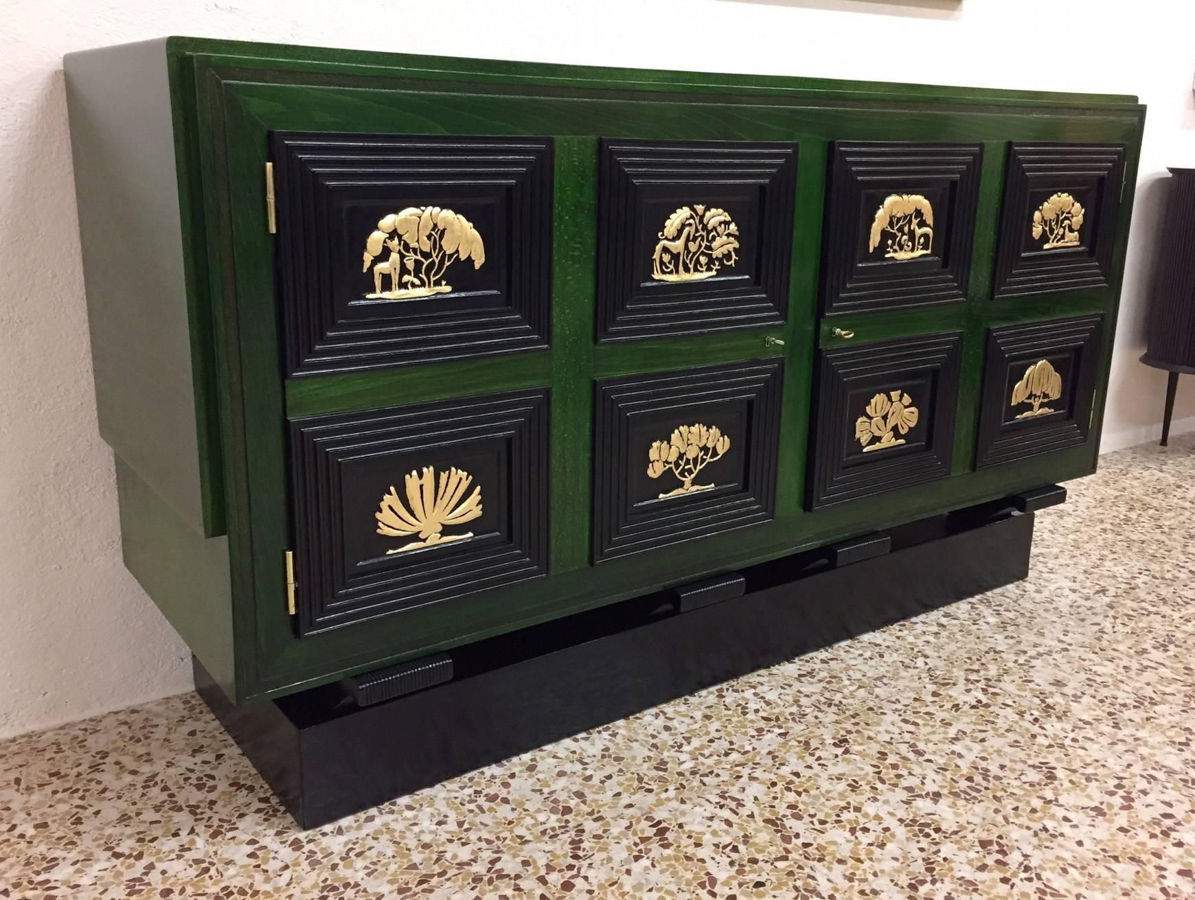 Fine 1930s, French Art Deco sideboard, with a particular green paint and some ebonized sections, gold leaf inlay and brass metalware.