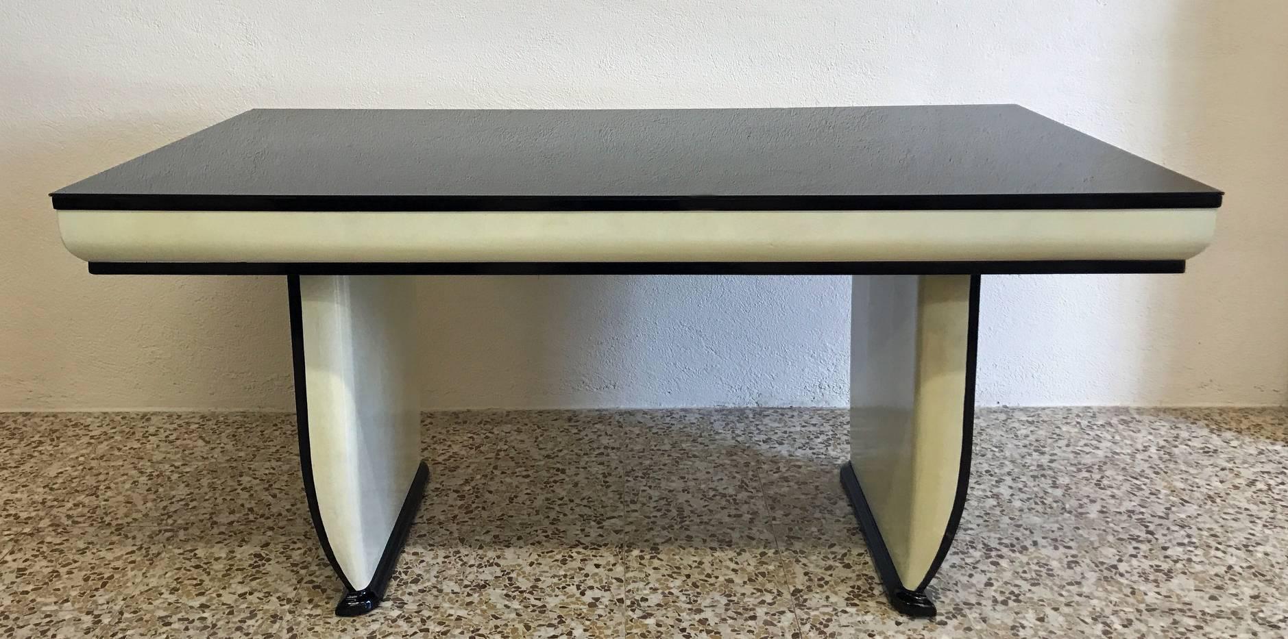 Fine and elegant Art Deco table, attributed to Osvaldo Borsani, famous Italian architect of the 1930s.
Restored to its original beauty, this table feature a black glass top which match perfectly with its legs which are half in parchment paper and