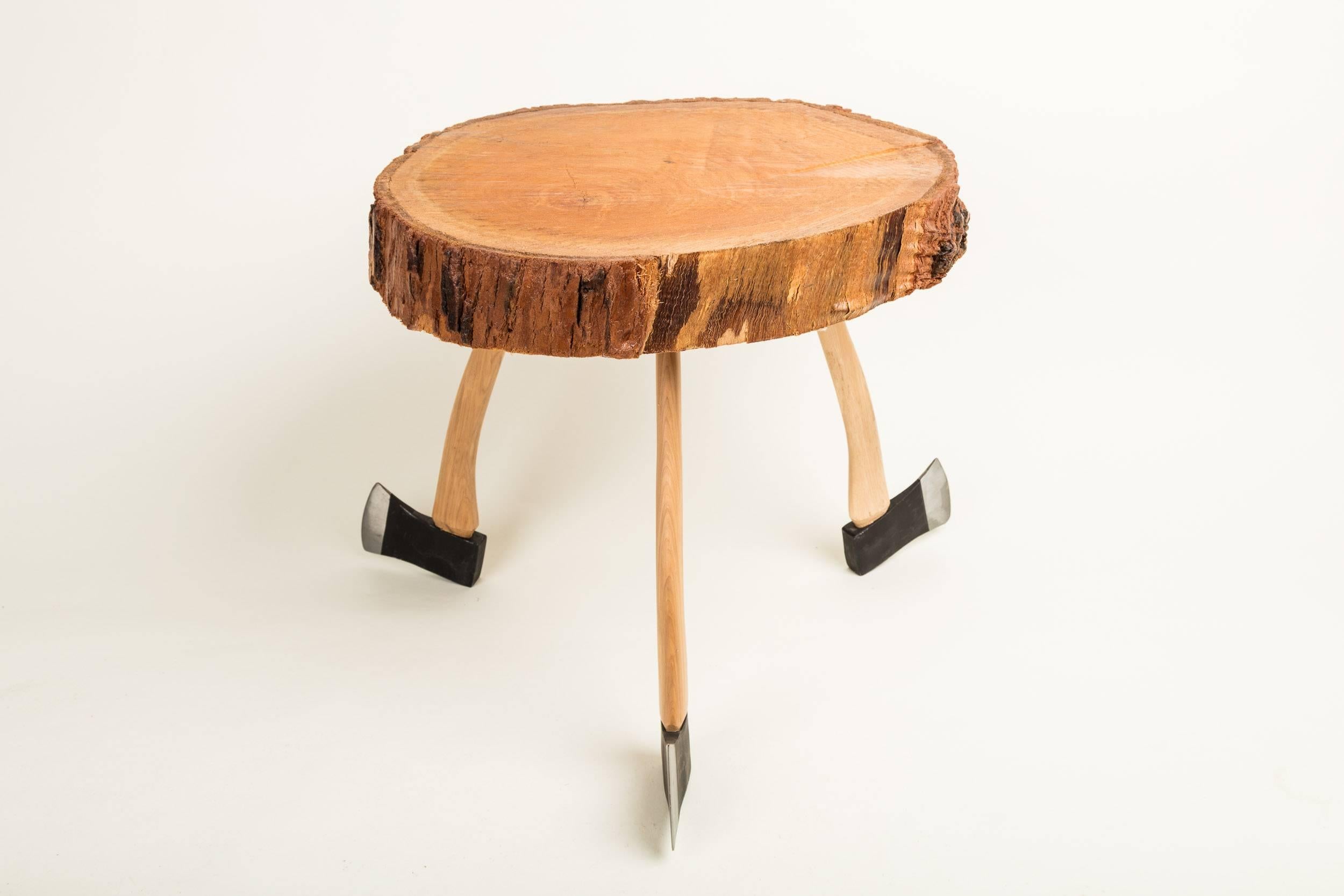 Made from a cross section of a felled pine tree, this unique item is elevated by its abstract base. Giving homage to lumberjack culture, this is more than a table, it's a true conversation piece. 

It's recommended to only use this table for