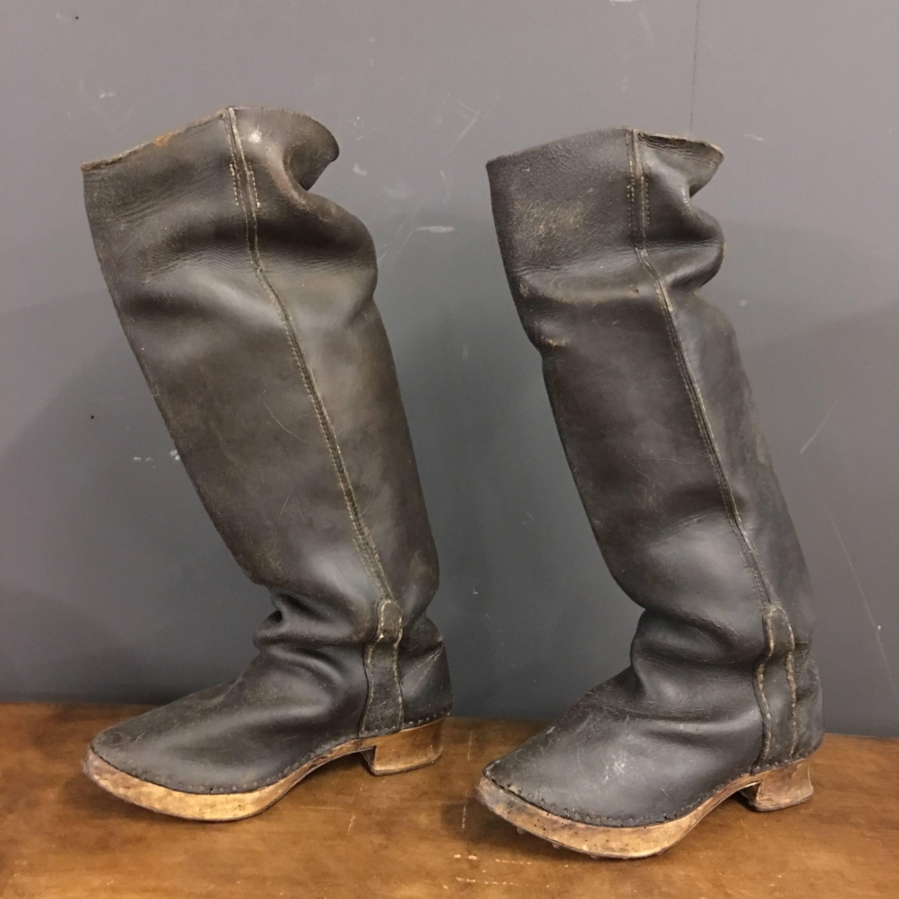 This decorative pair of antique fisherman's boots was used in France, late 18th century.
Made of black leather on a solid wooden sole with an iron edge and studs, in order to prevent slipping.

With signs of use this decorative pair of antique