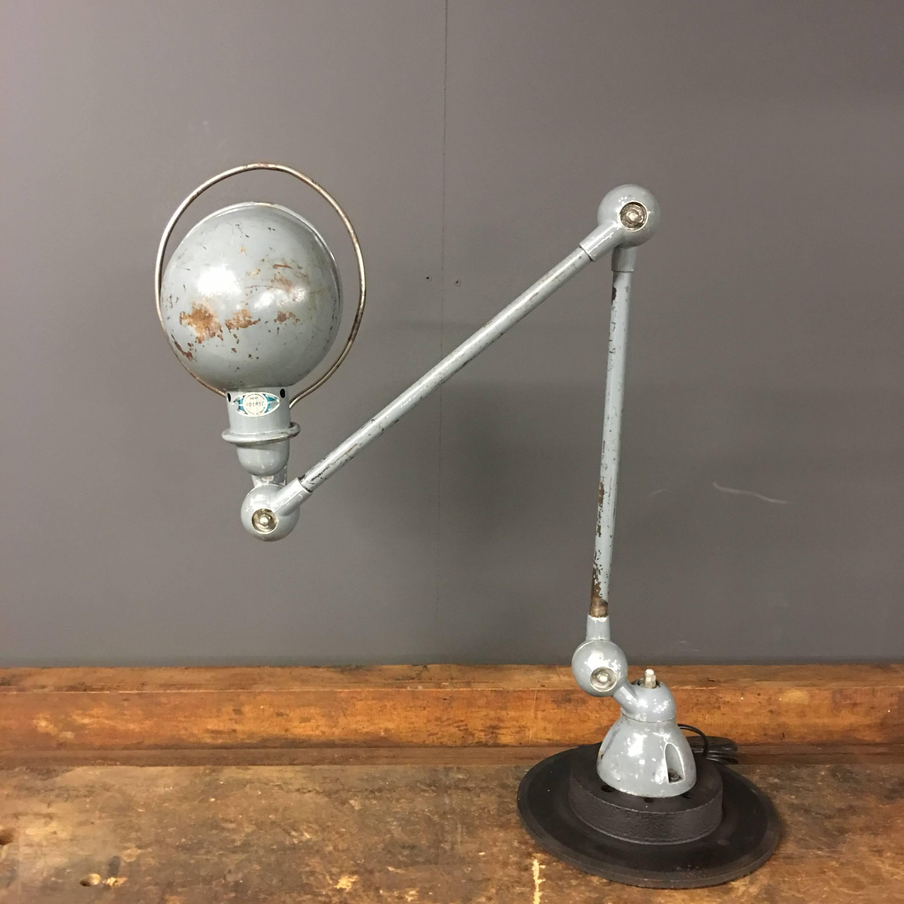 This French Industrial workbench light was designed by Jean-Louis Domecq and manufactured by Jieldé in Lyon, France, in the 1950s. It is mounted on a black painted brake disc.