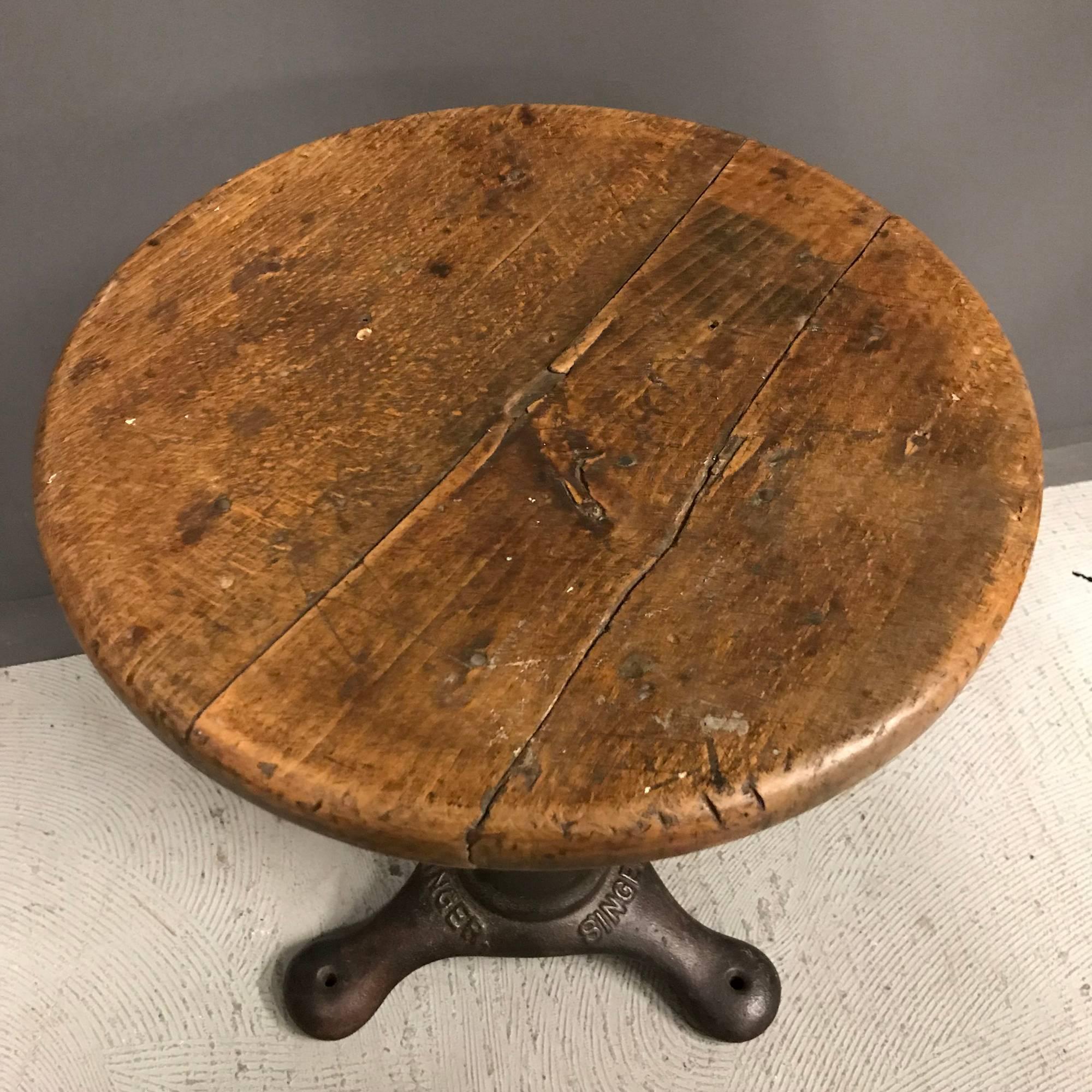 Industrial workshop stool by Singer. Heavy cast iron base with solid oak top. Made in France during the 1930s. This stool remains in good condition.