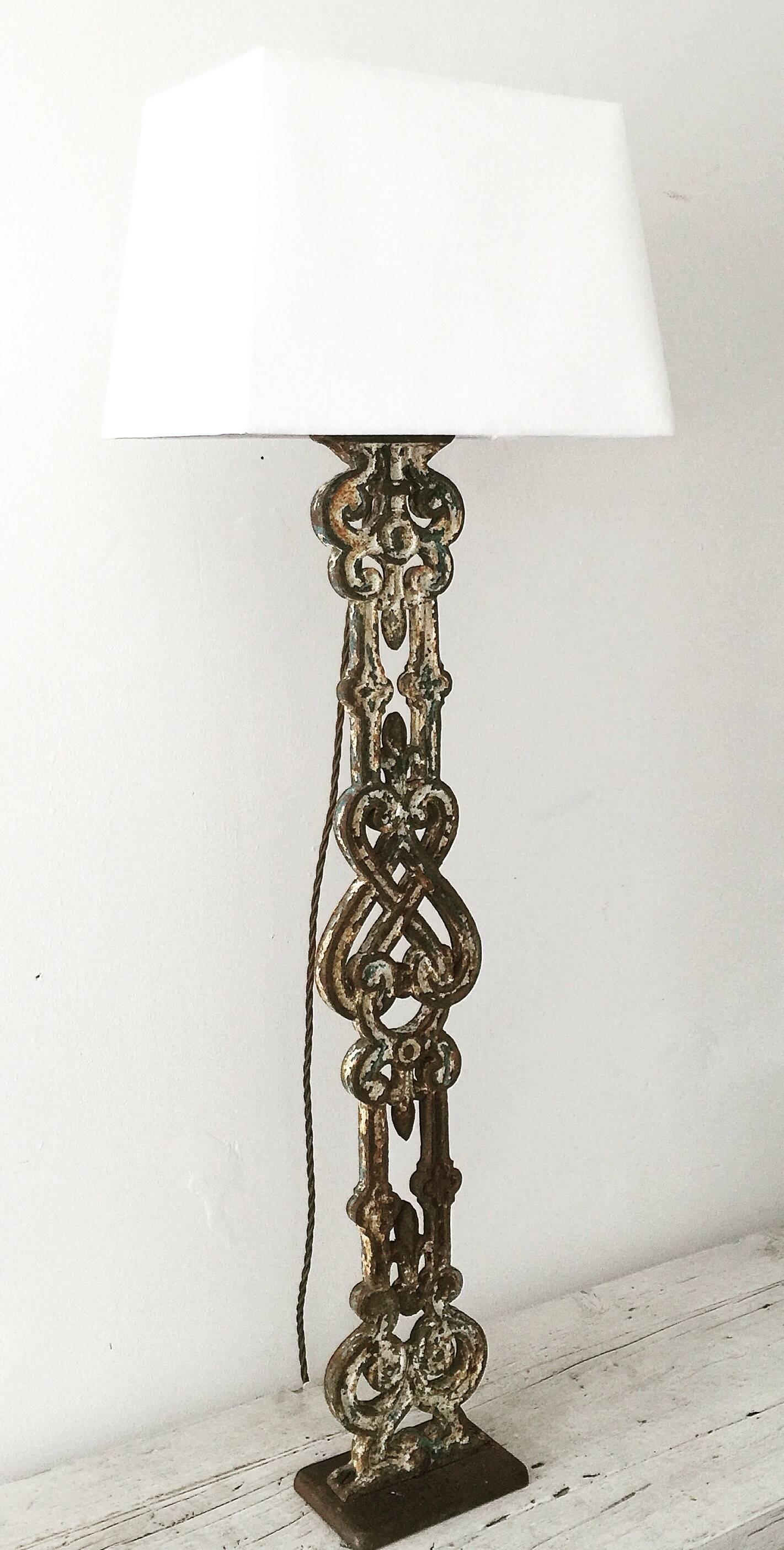 Large 19th century cast iron balustrade converted into a table lamp mounted onto a cast iron base with brass fittings and lampshade.
